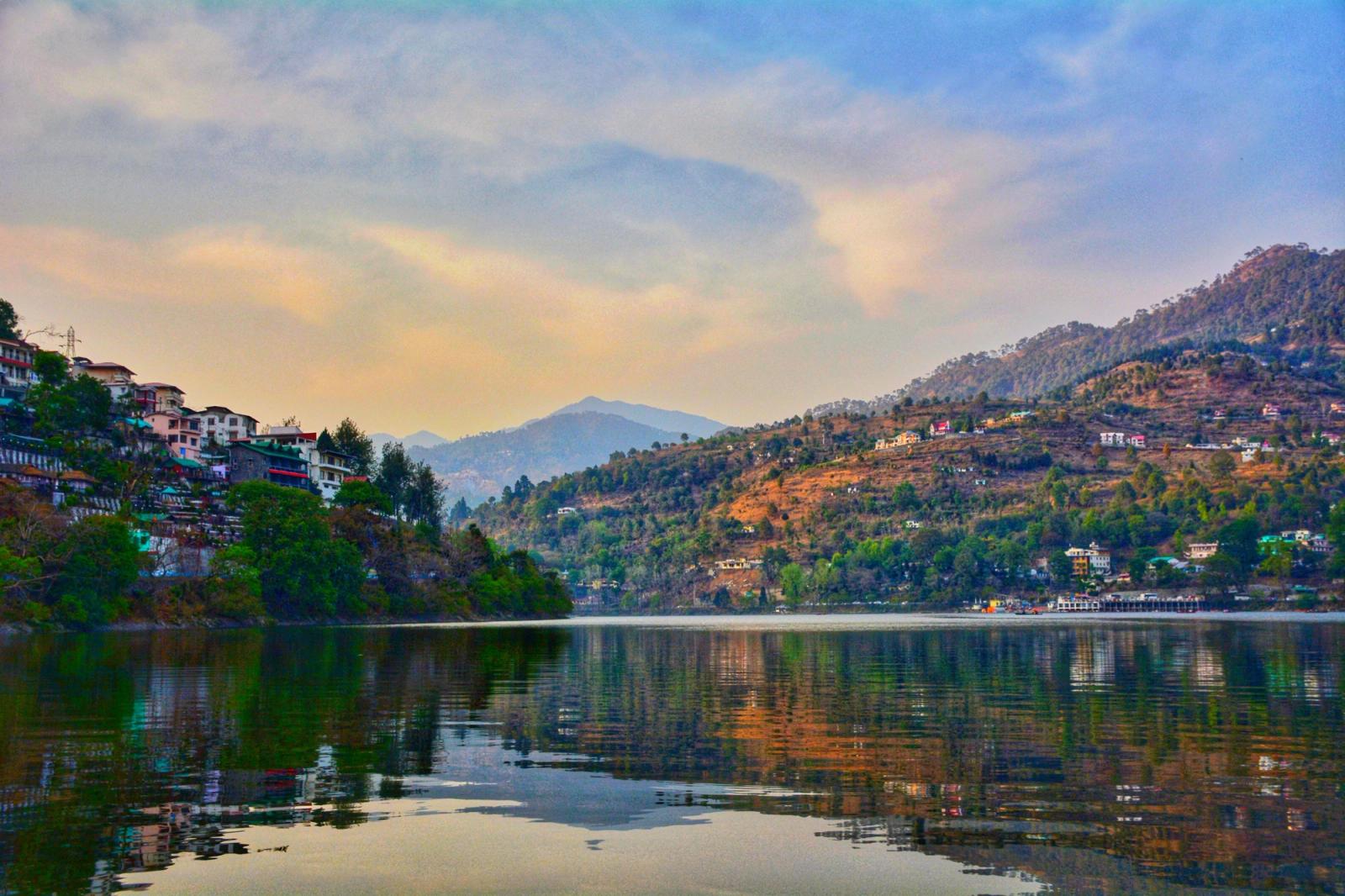 A hillside town reflected in a still lake at dusk