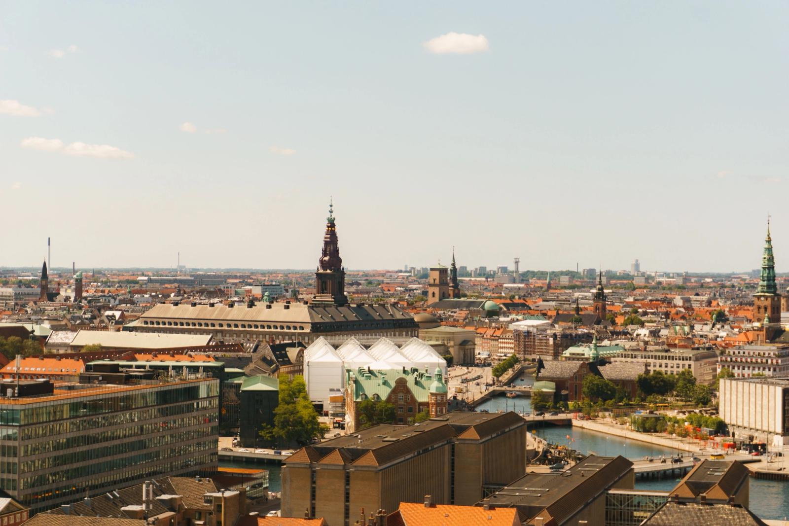 Panoramic aerial view of Copenhagen's historical architecture and waterways under a clear sky