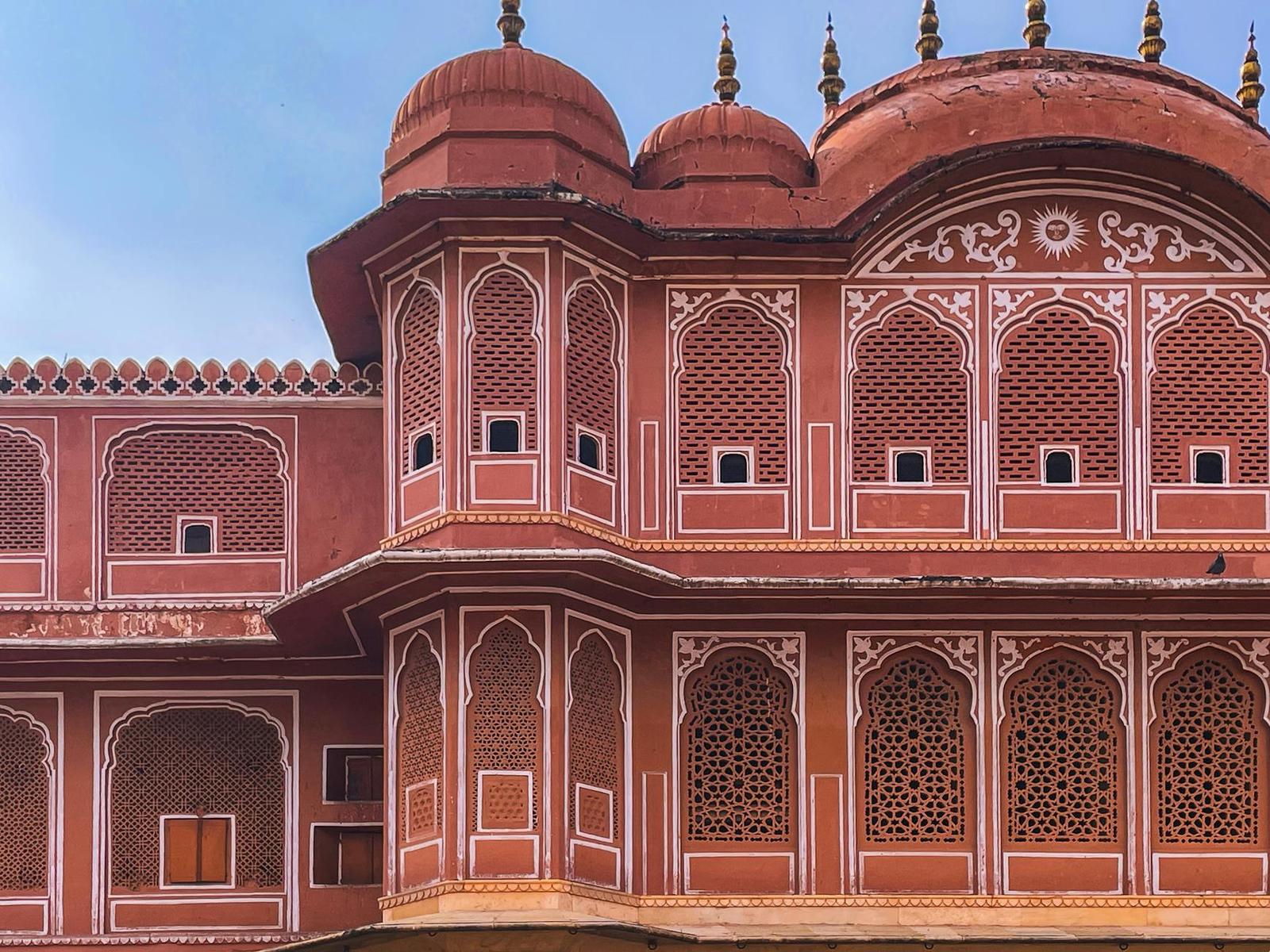 Domed corner turrets on a red sandstone palace with lattice screens
