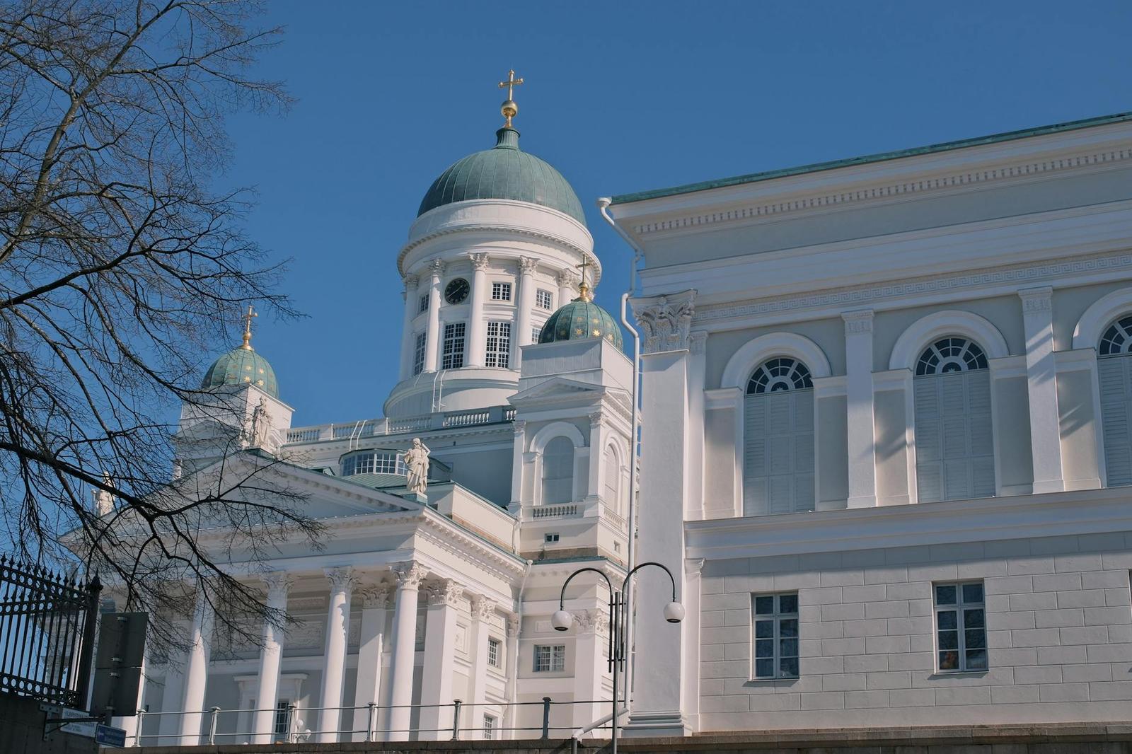 Green-domed cathedral with white columned facade under a clear sky