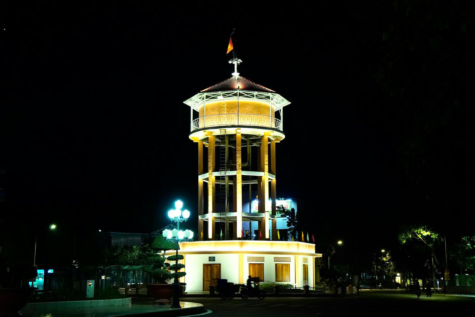 An octagonal glass tower lit gold against the night sky