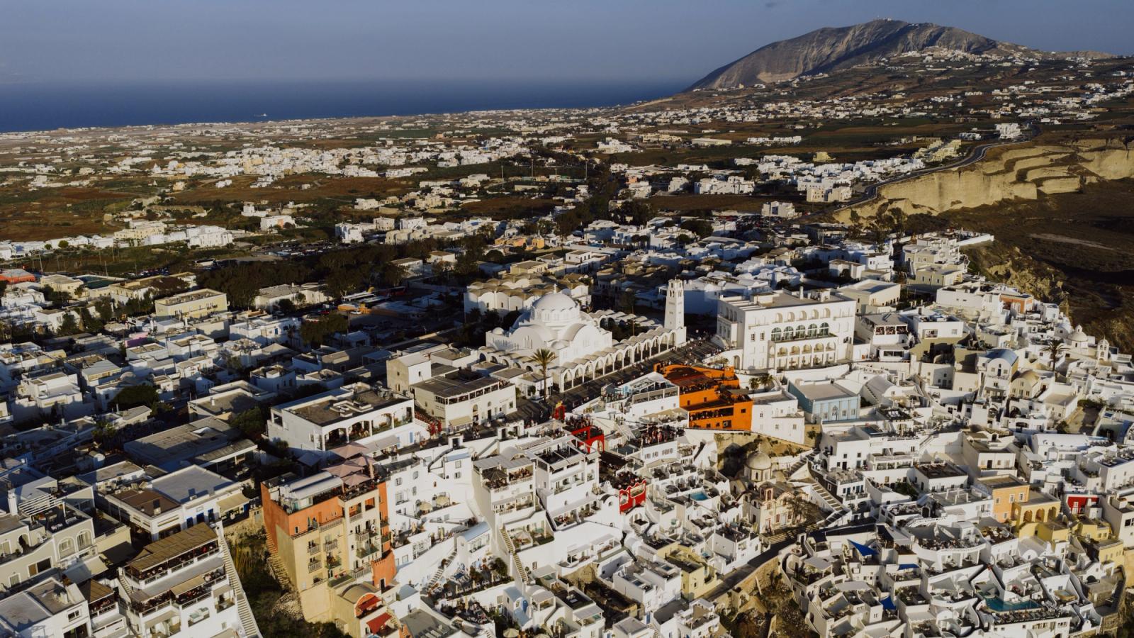 Aerial photograph showcasing the whitewashed buildings and beautiful landscapes of Fira, Santorini, Greece