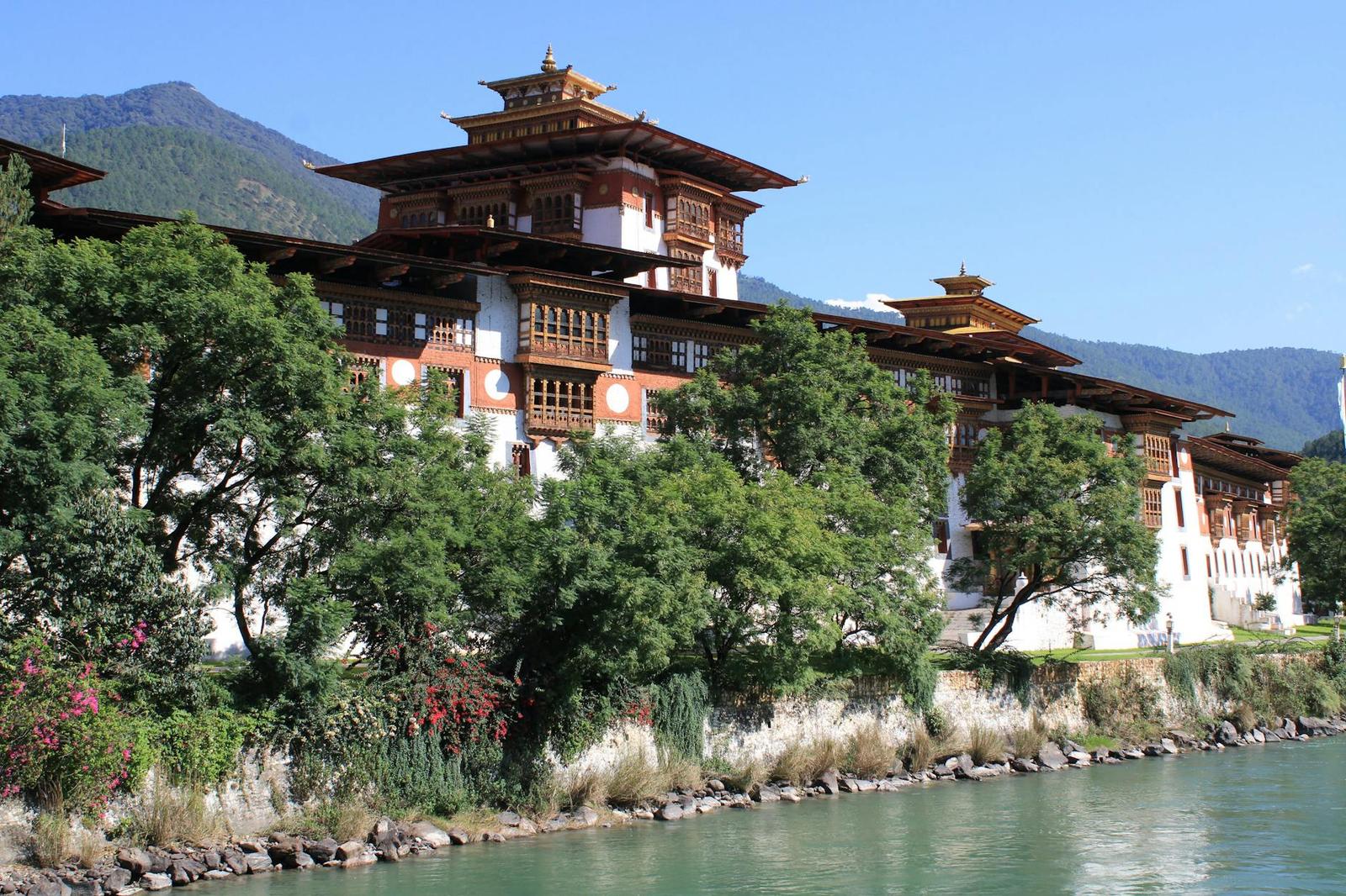 Scenic view of Punakha Dzong along a river with lush greenery in Bhutan
