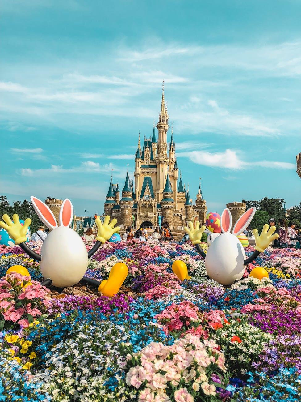 Vibrant flowers and playful decorations adorn the iconic Tokyo Disneyland Castle in a festive springtime setting