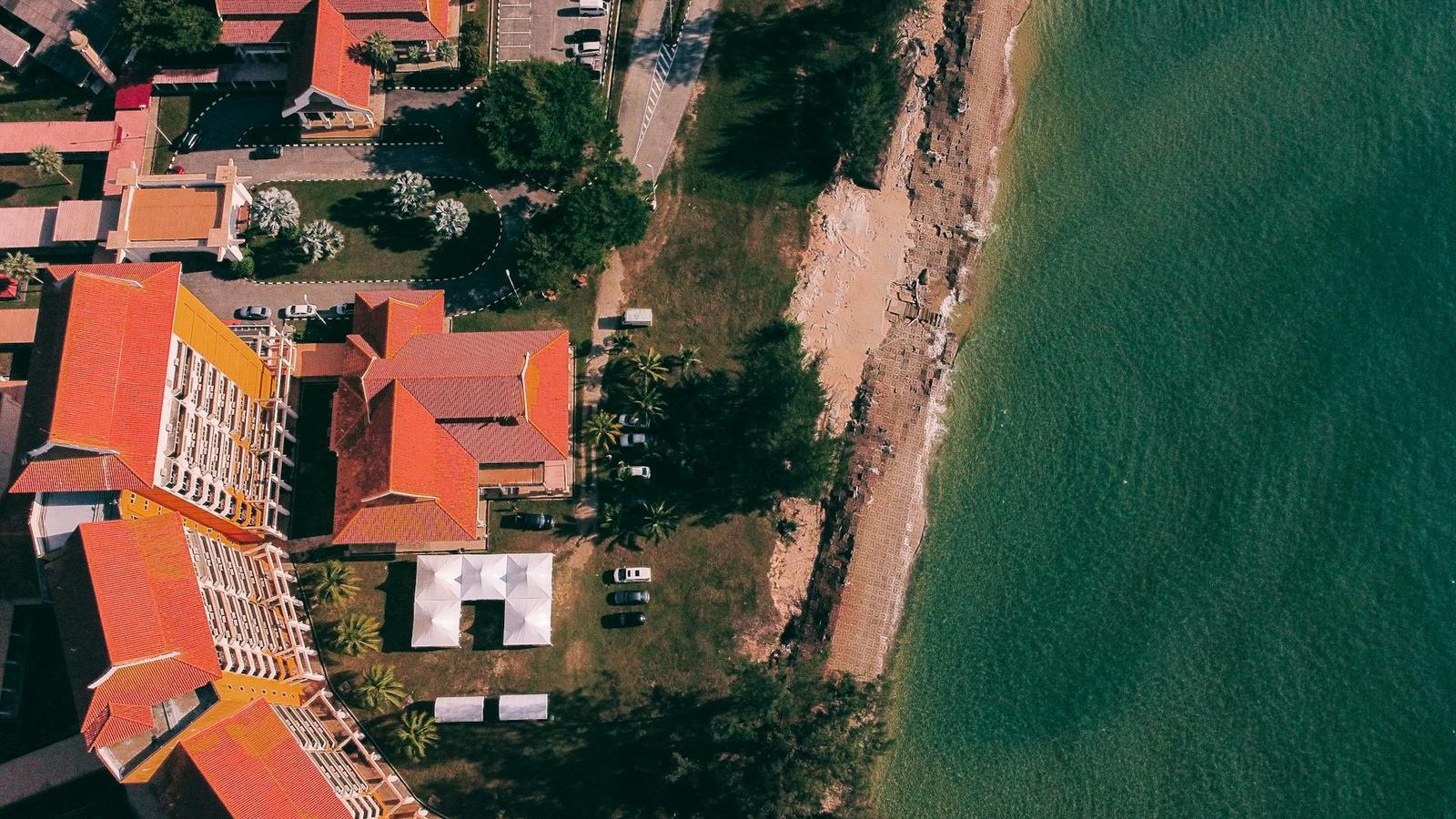 Aerial view of a red-roofed resort along a rocky shoreline