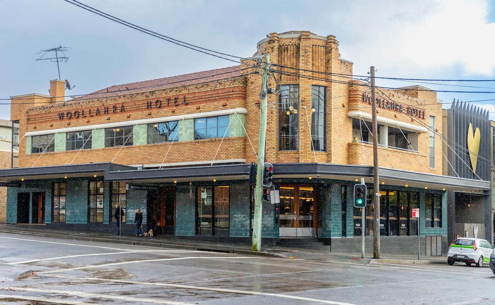 A heritage brick corner hotel building with awnings over a street pavement