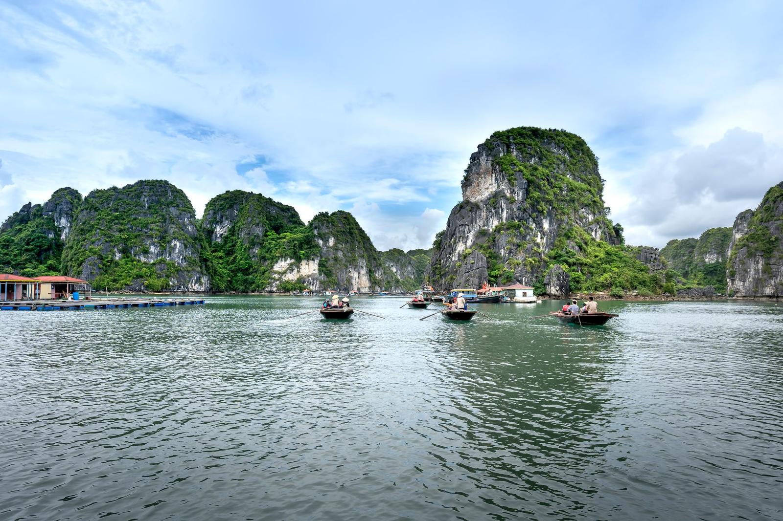Tranquil scene of boats navigating the limestone karsts in beautiful Halong Bay, Vietnam