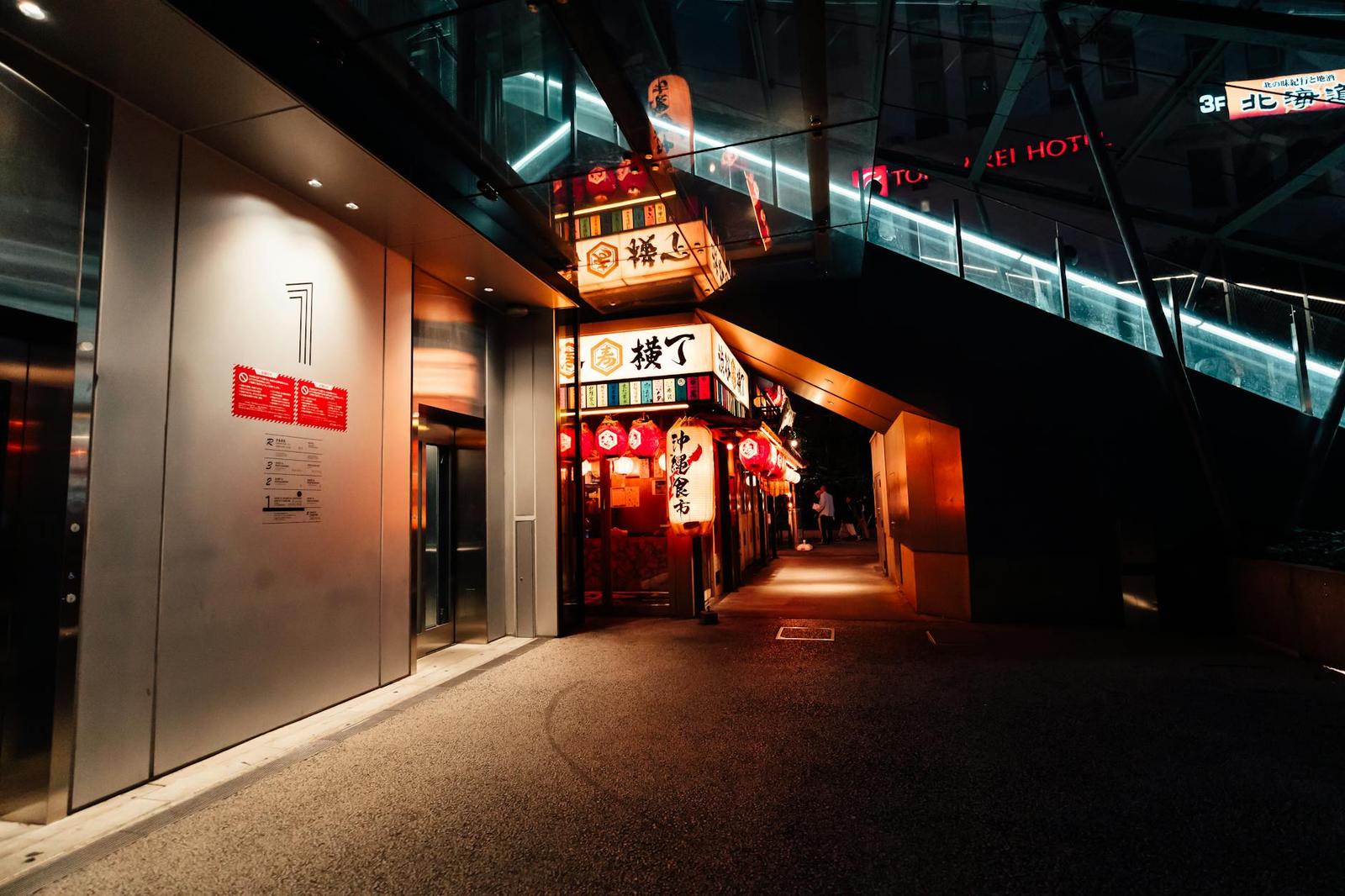 An illuminated alleyway lined with glowing restaurant signs at night