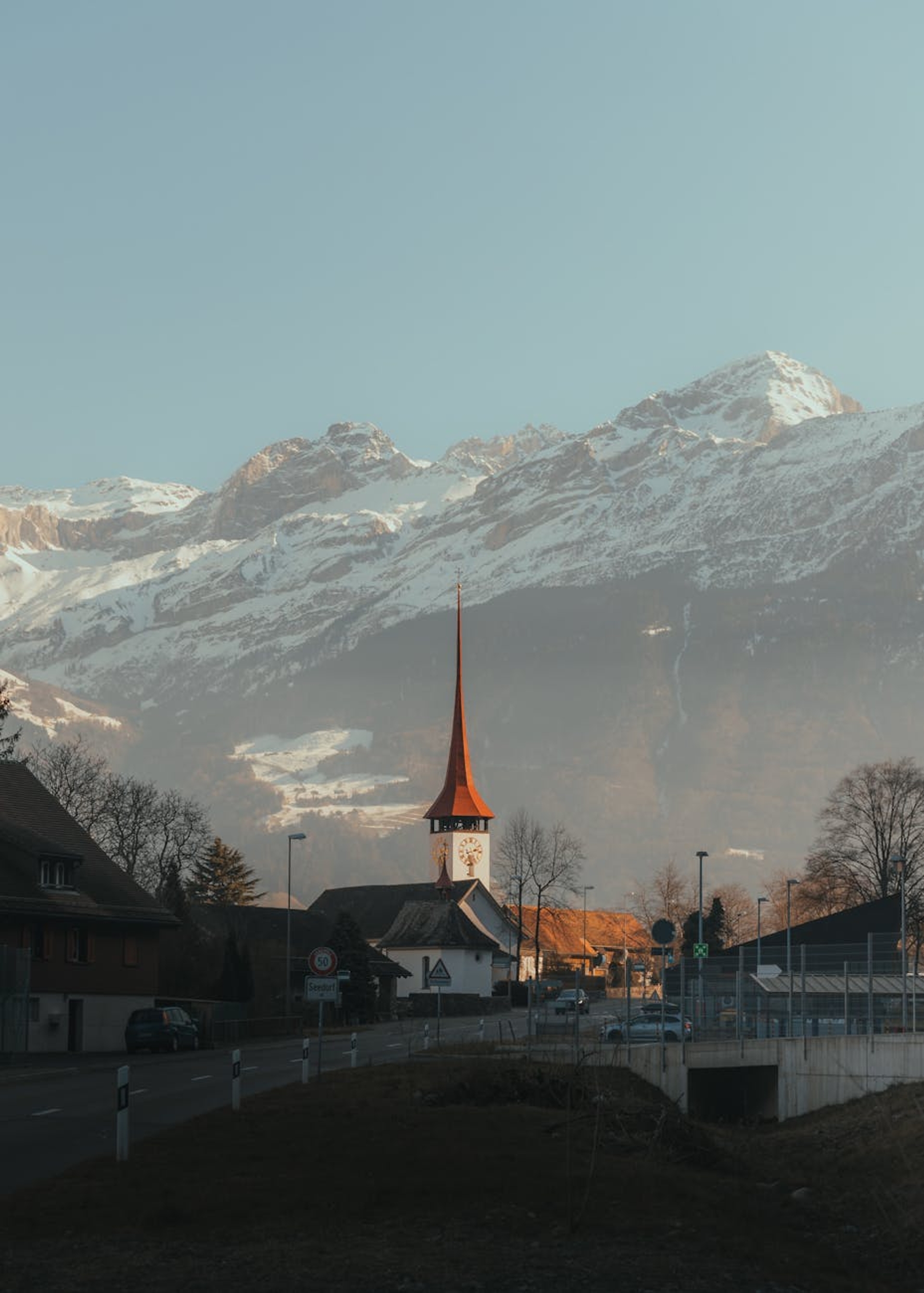 Scenic view of a Swiss village church amidst snowcapped mountains