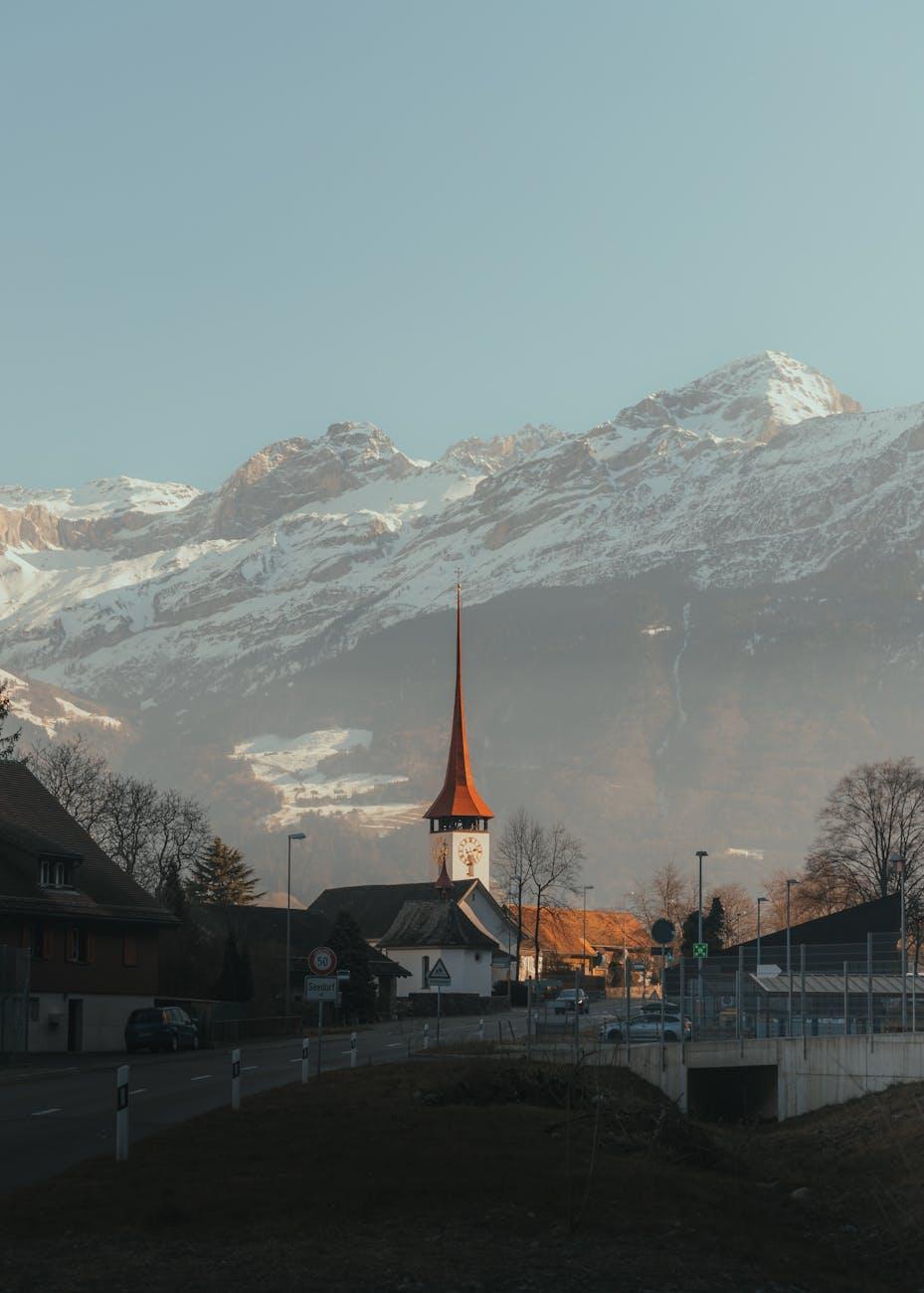 Scenic view of a Swiss village church amidst snowcapped mountains