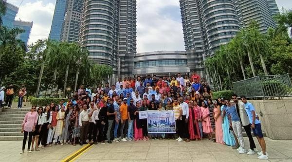 A large group posing in front of the Petronas Towers, Malaysia.