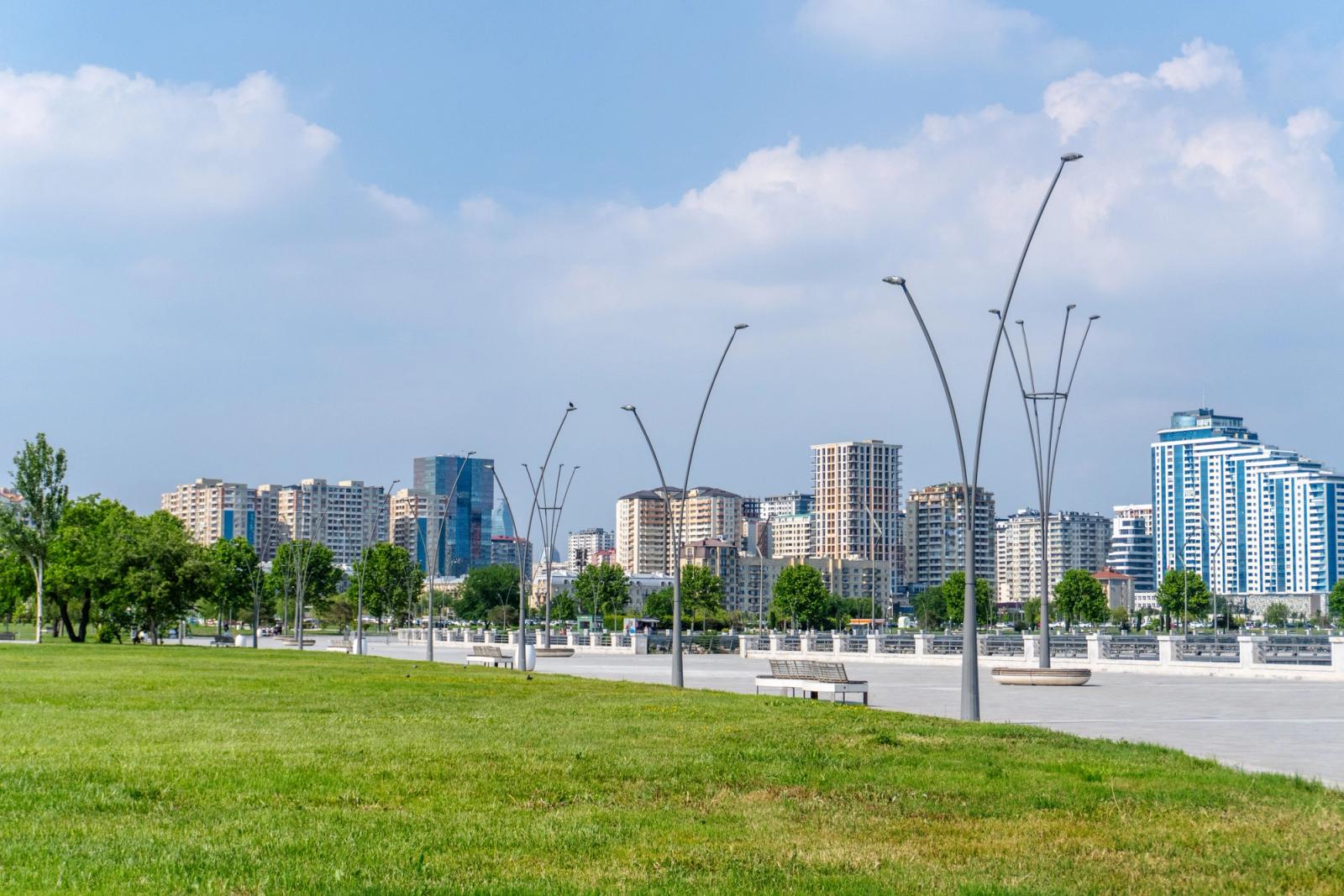 Stunning cityscape of Baku featuring modern architecture and a lush green park under a clear blue sky