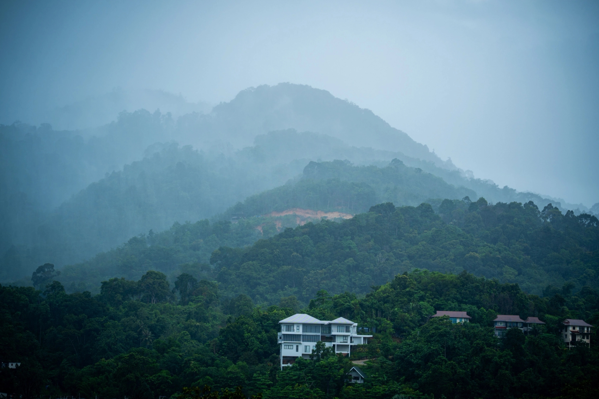 Misty mountain view on a rainy day in Phuket, Thailand, showcasing lush tropical greenery