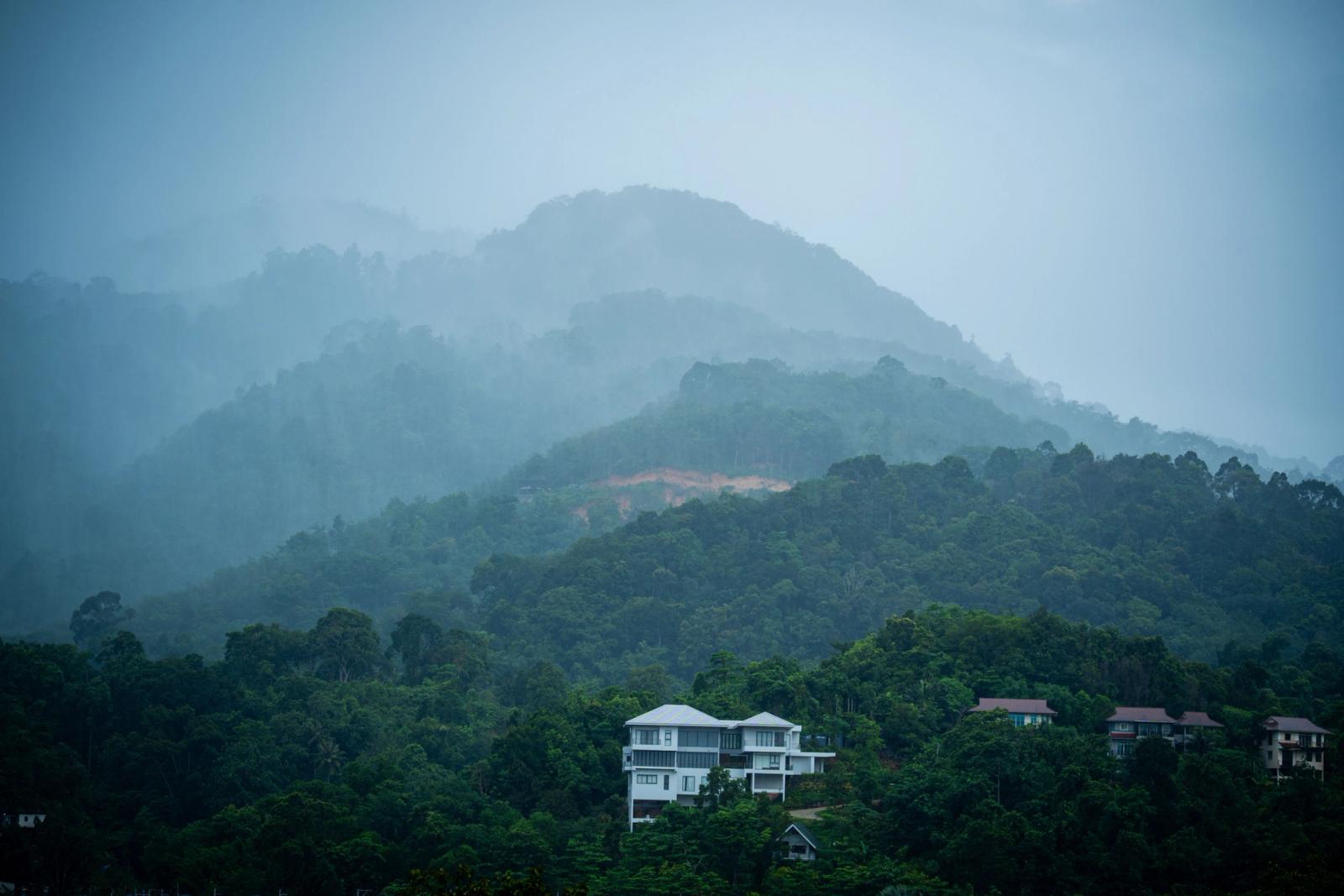 Misty mountain view on a rainy day in Phuket, Thailand, showcasing lush tropical greenery