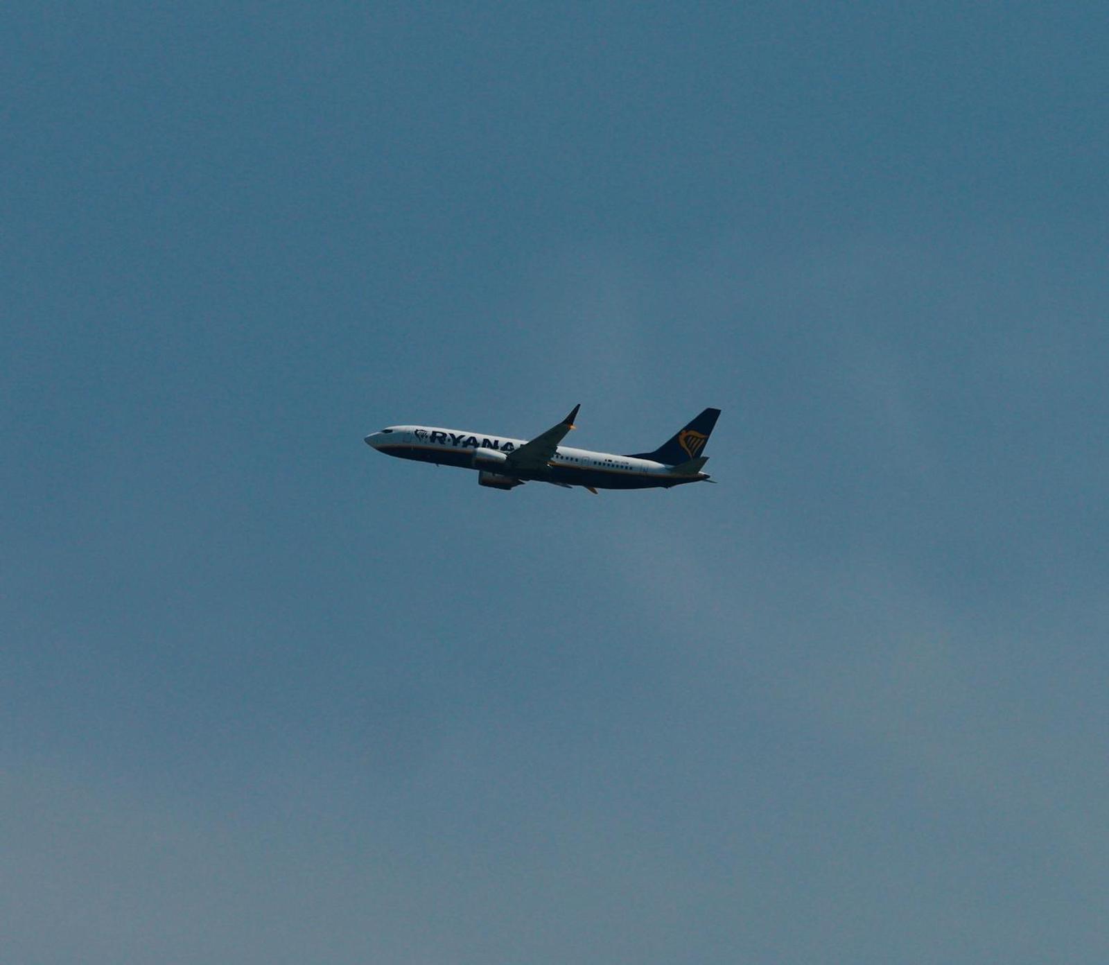 A passenger jet climbing against a plain blue sky
