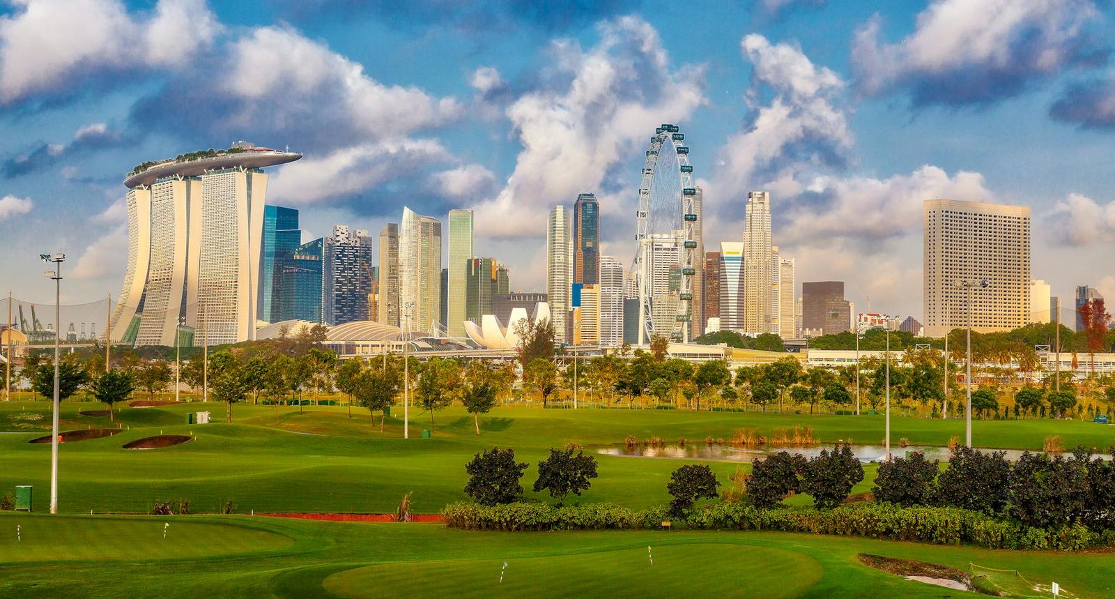 Stunning view of Singapore's skyline including Marina Bay Sands and a lush golf course in the foreground