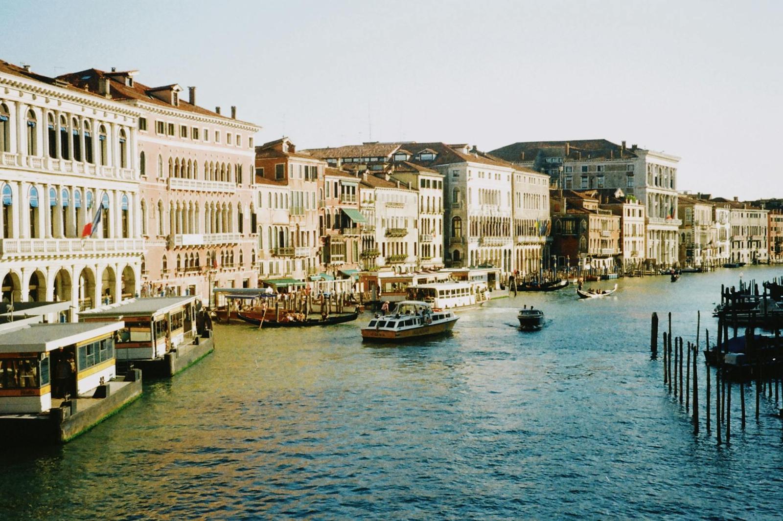 Canal boats passing waterfront palaces along a wide city waterway