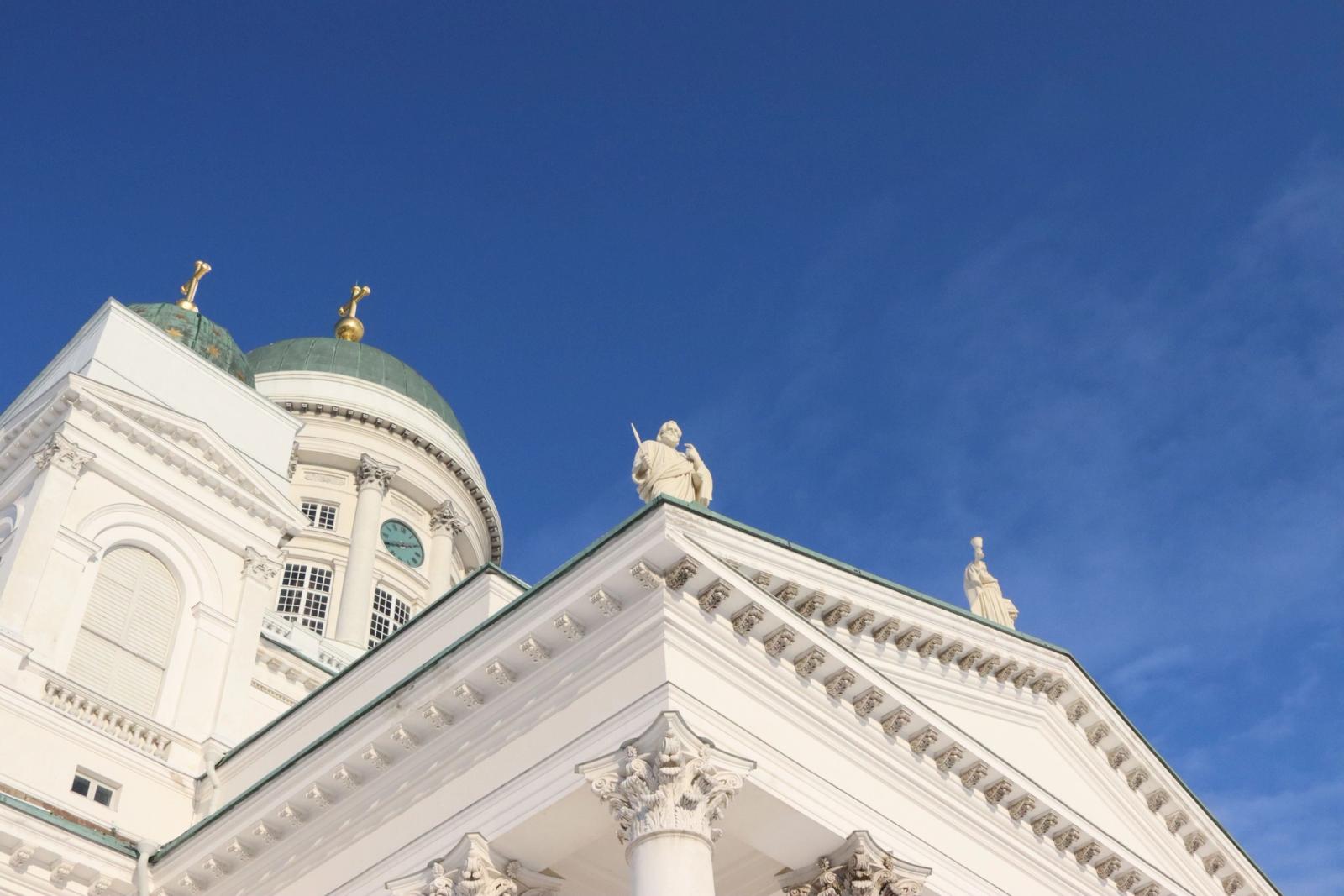 Low angle view of Helsinki Cathedral's neoclassical facade under a clear blue sky