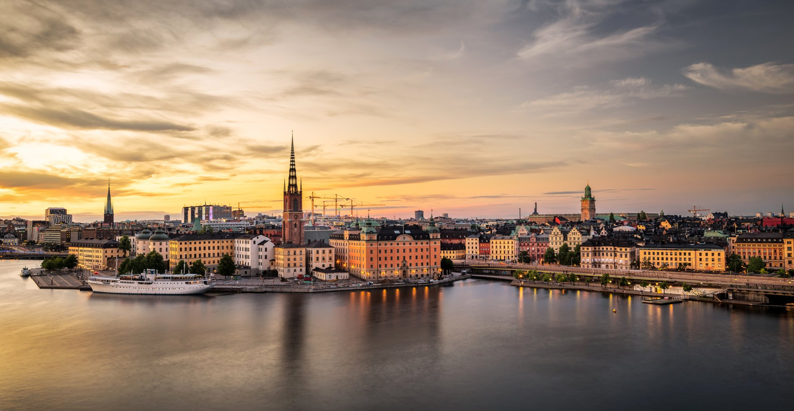 A waterfront old-town skyline glowing at sunset
