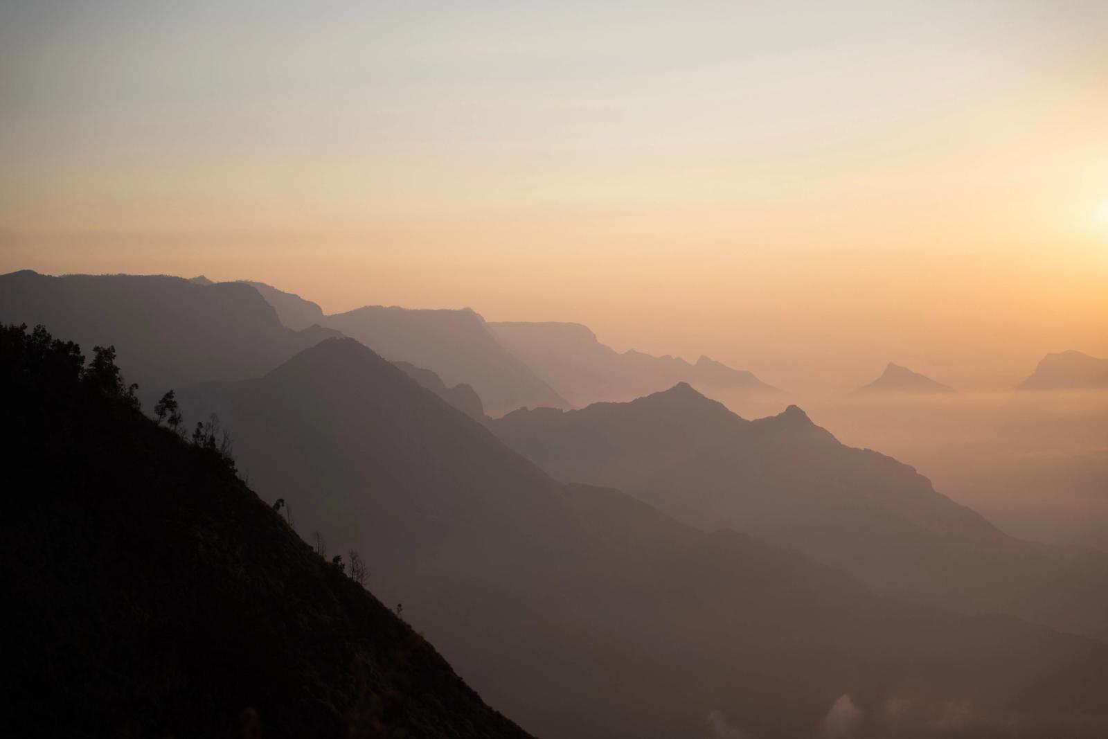 Stunning sunrise view over a misty mountain range in India, capturing serene and peaceful landscape