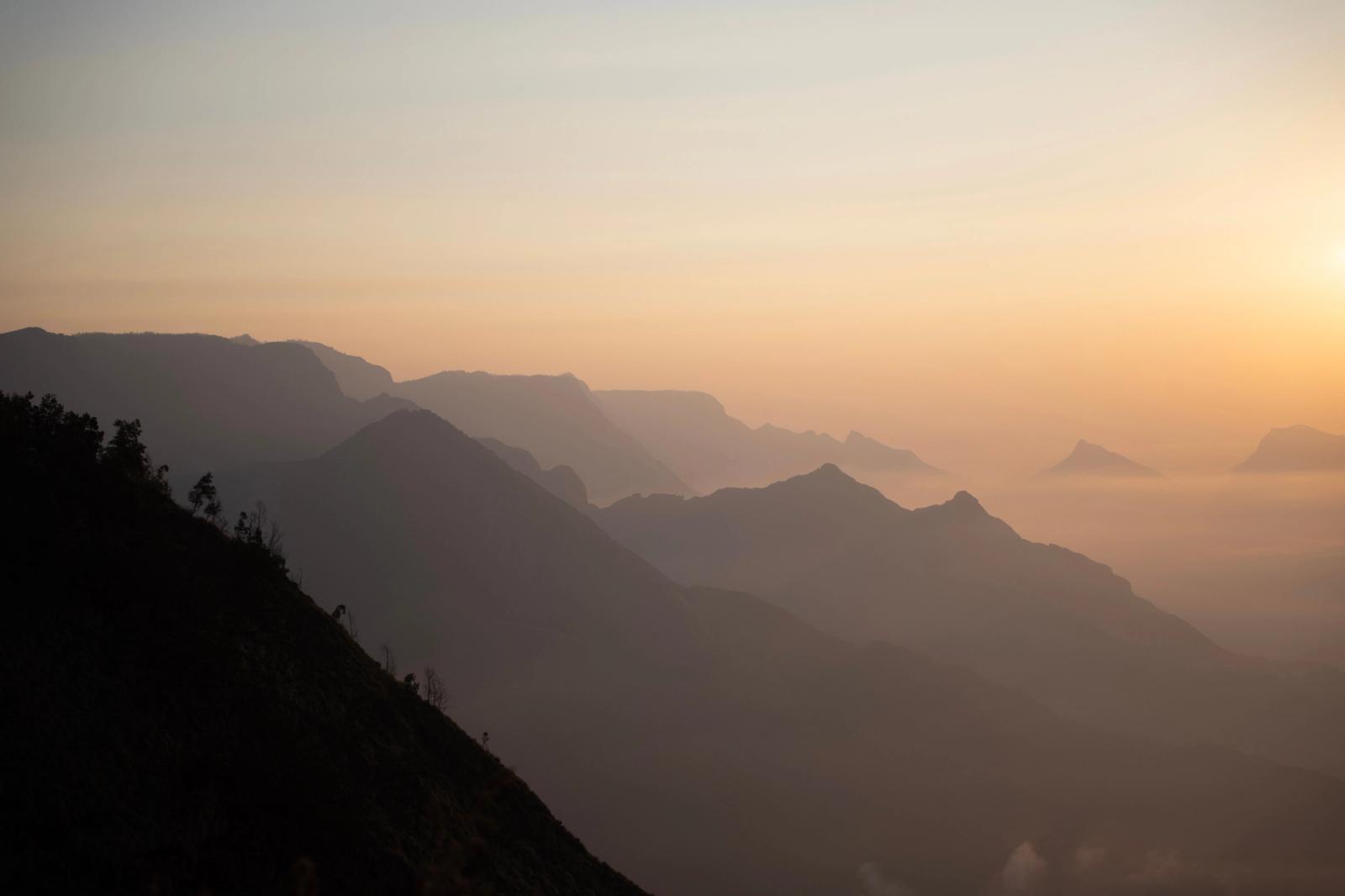 Stunning sunrise view over a misty mountain range in India, capturing serene and peaceful landscape