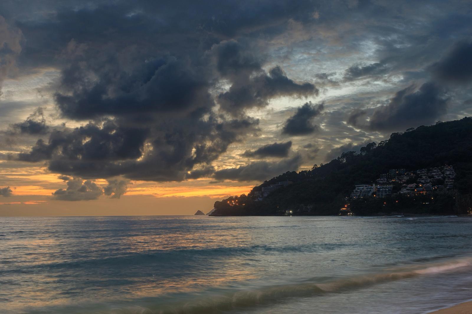 Stunning sunset over Patong Beach, Phuket, with dramatic clouds and calm waves