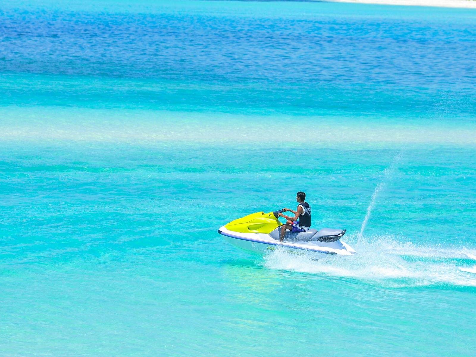 A jet ski cutting across a bright turquoise lagoon