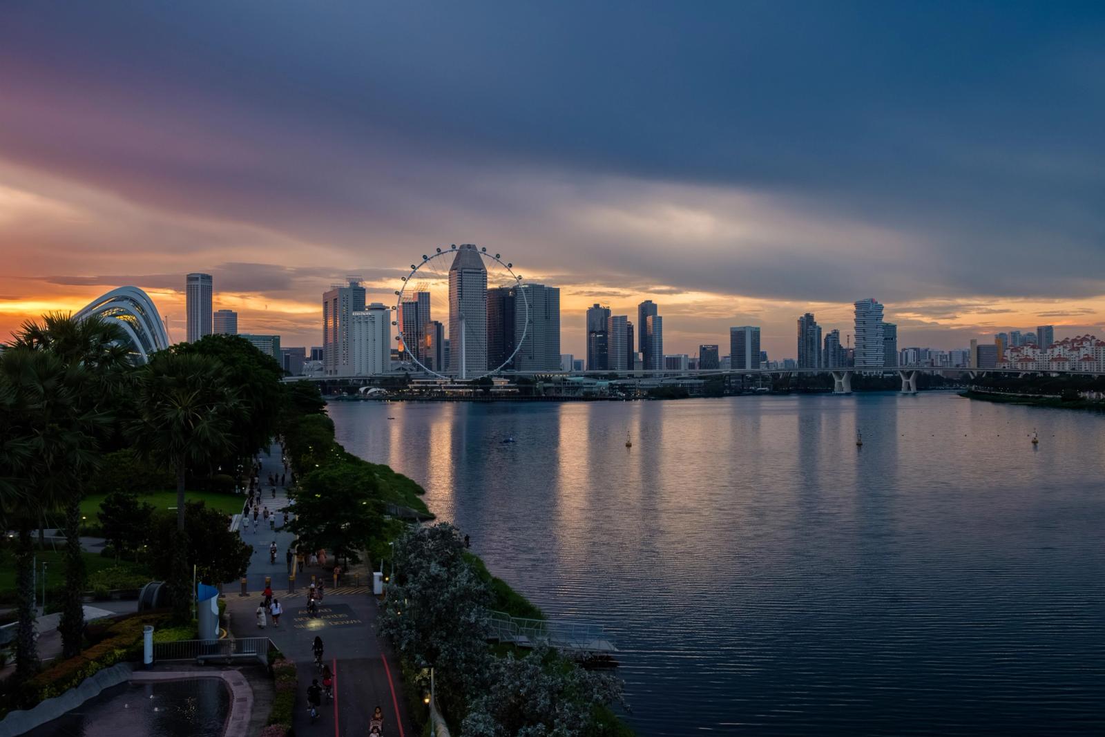 Vibrant sunset view of Singapore skyline featuring the iconic Ferris wheel and waterfront