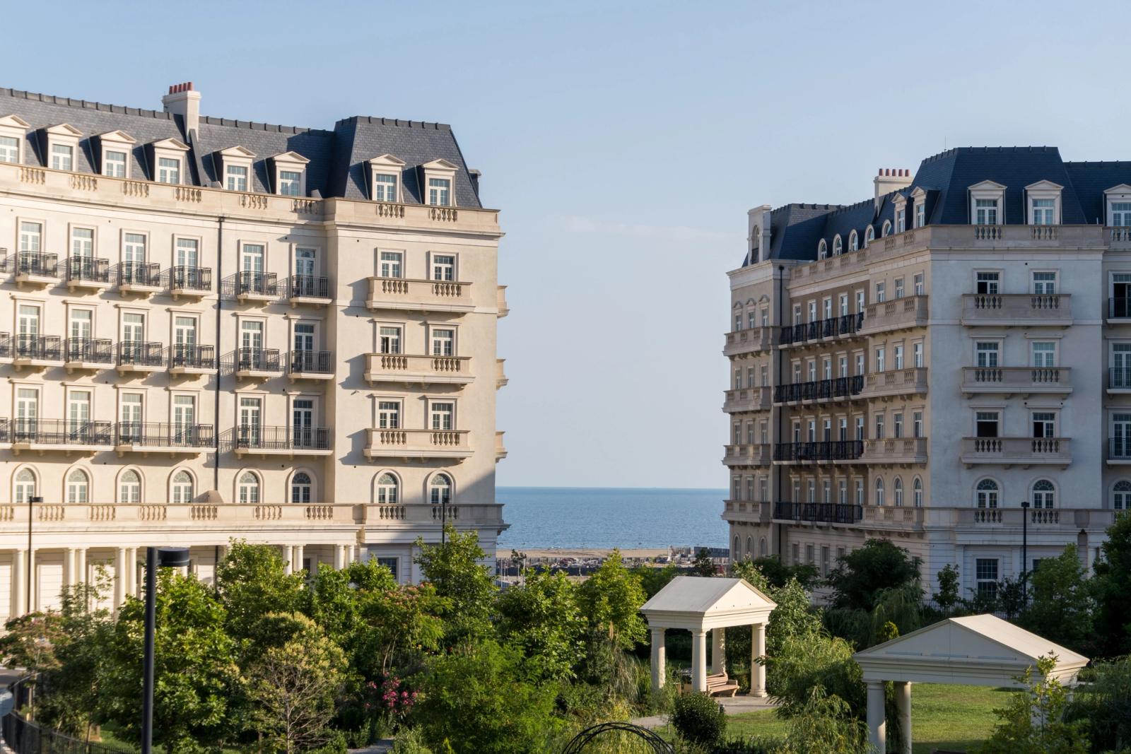 Beautiful classic buildings with a sea view in Baku, showcasing elegant architecture and lush greenery