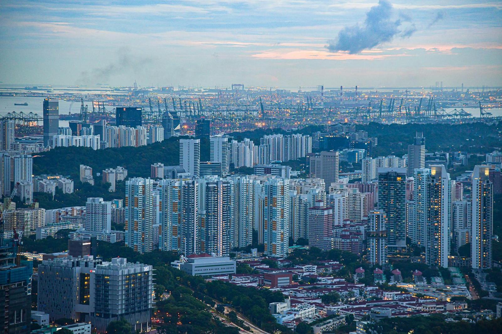 Aerial view of dense high-rise apartment blocks stretching toward a distant port