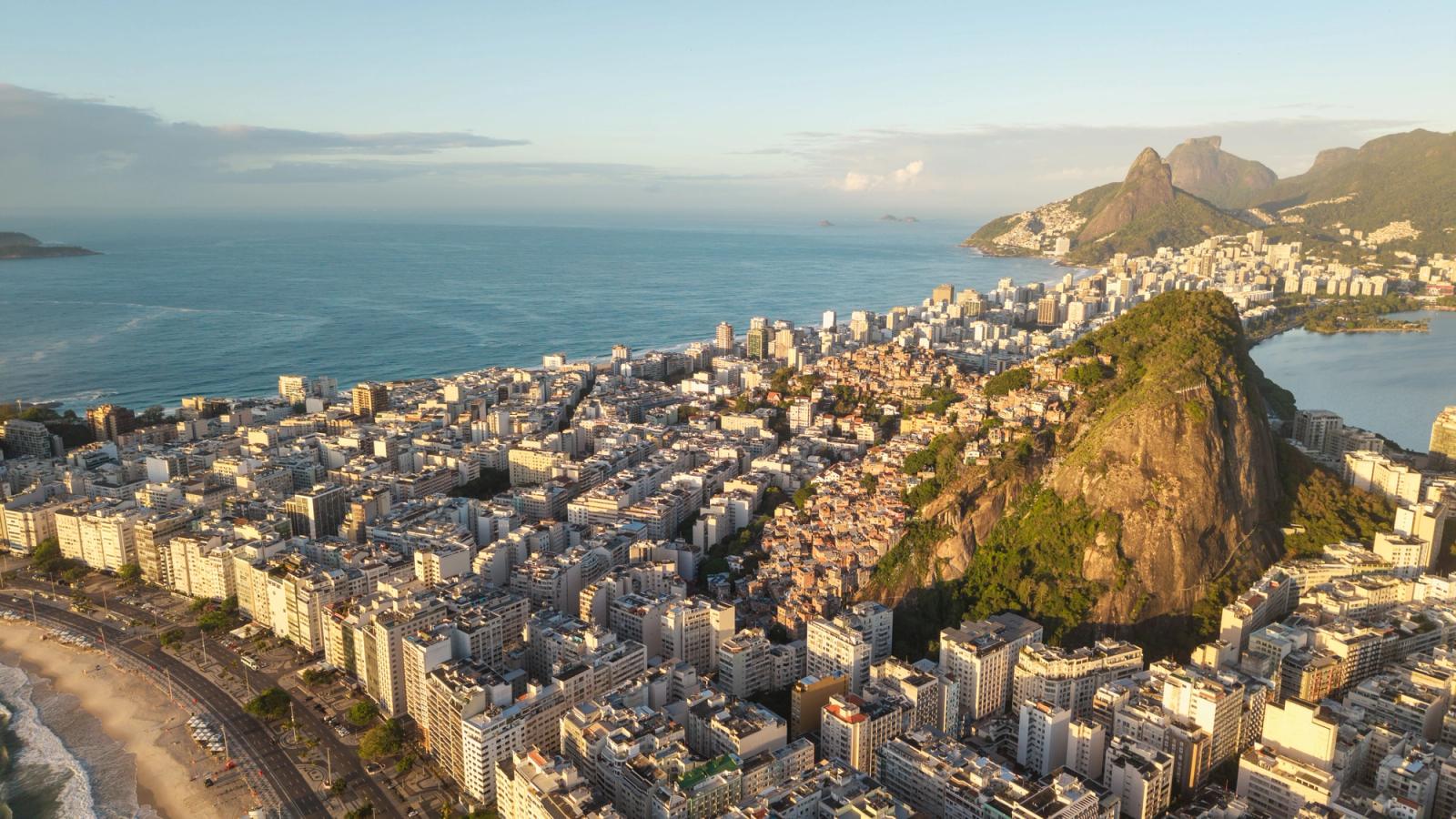 A breathtaking aerial view of Rio de Janeiro's coastline with urban landscape and mountain backdrop at sunrise