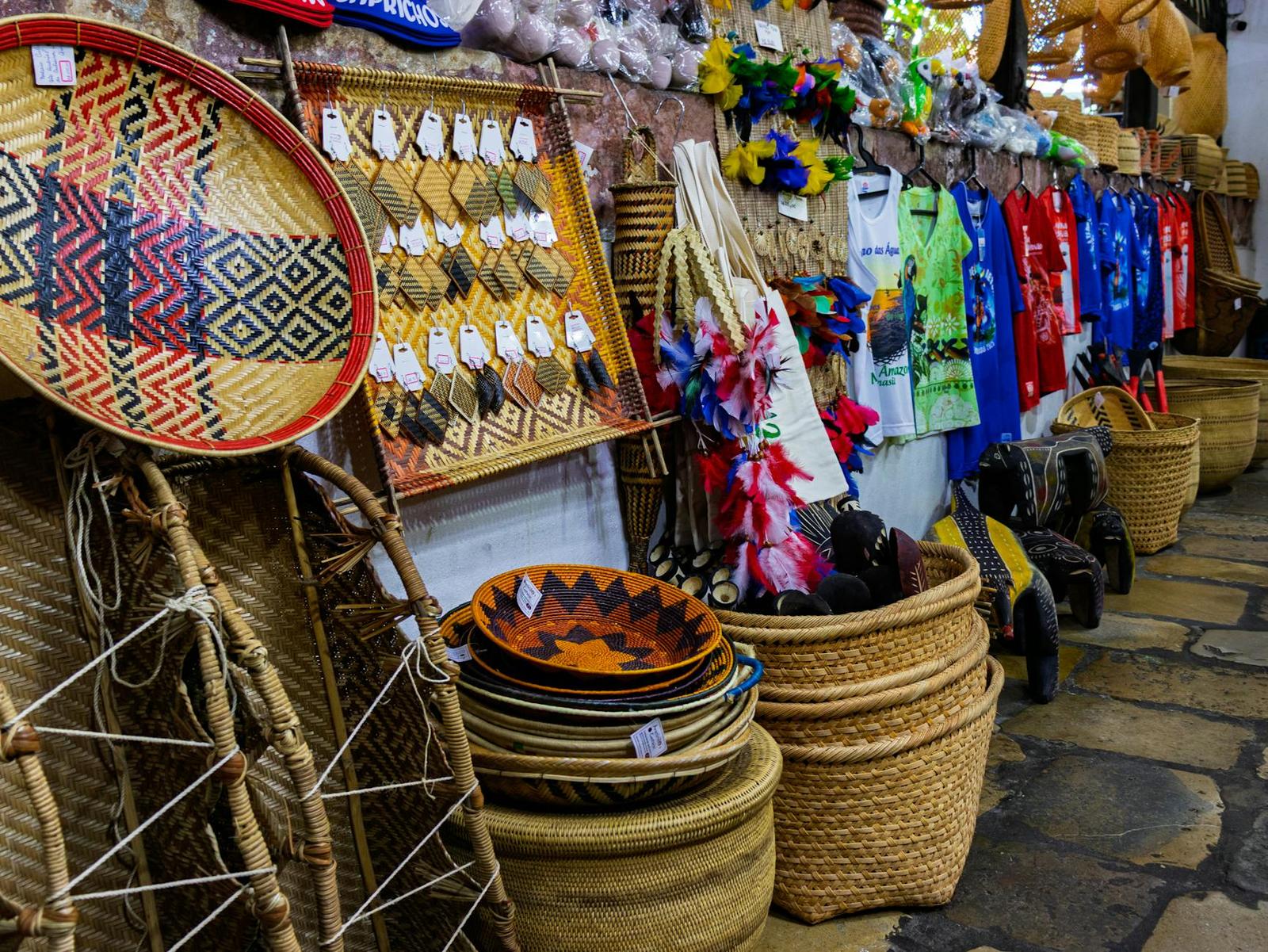 Woven baskets and colourful textiles stacked at a market stall