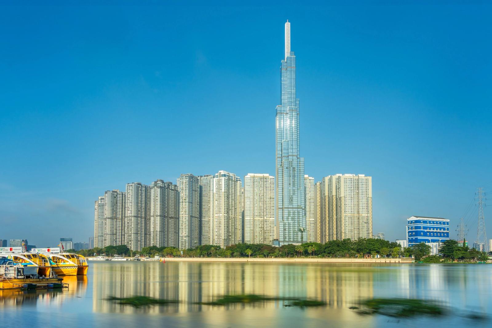 Slender glass skyscraper towering above a dense high-rise city skyline