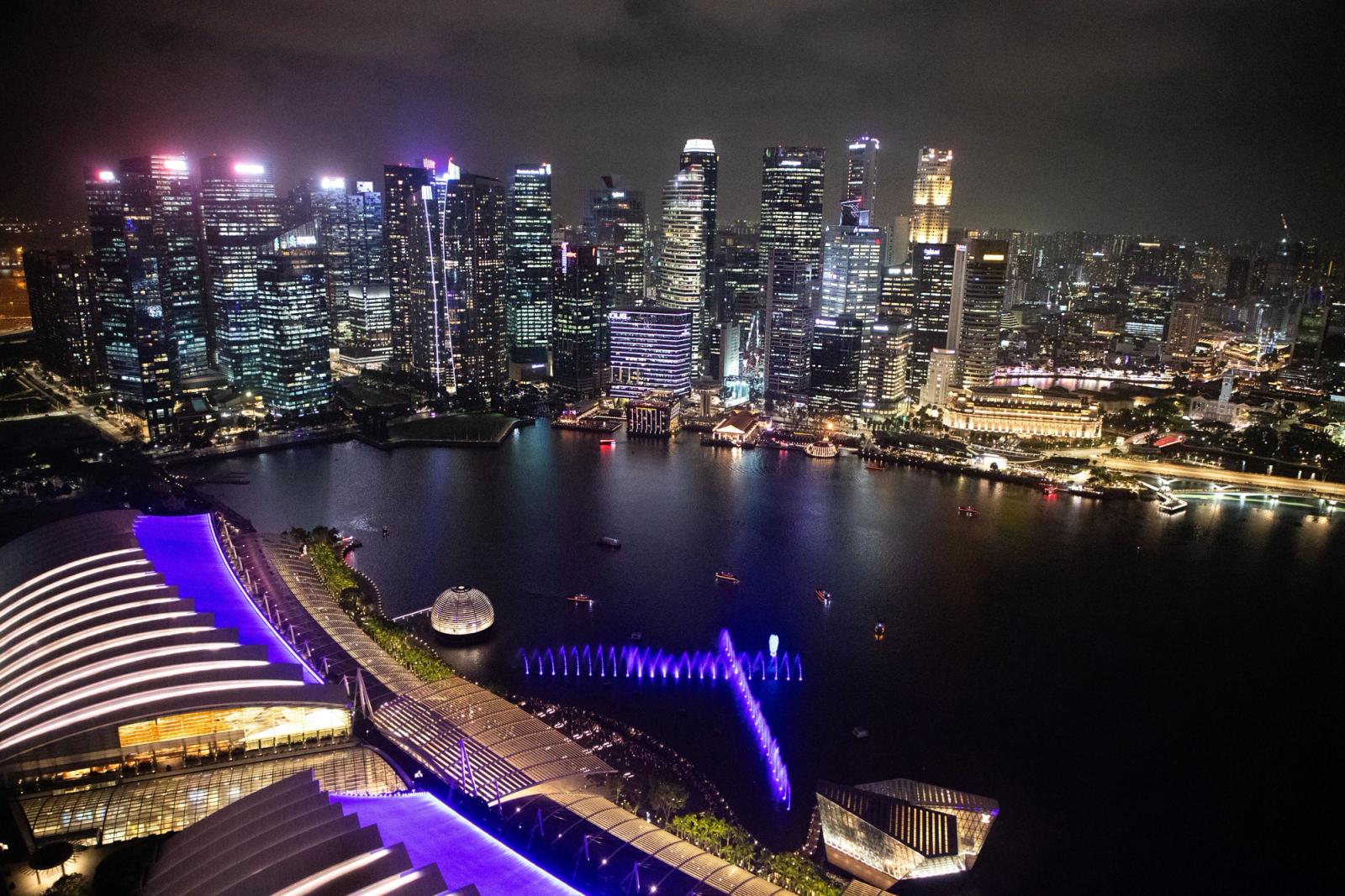 Breathtaking aerial view of Singapore's illuminated skyline at night, showcasing modern architecture and vibrant city life