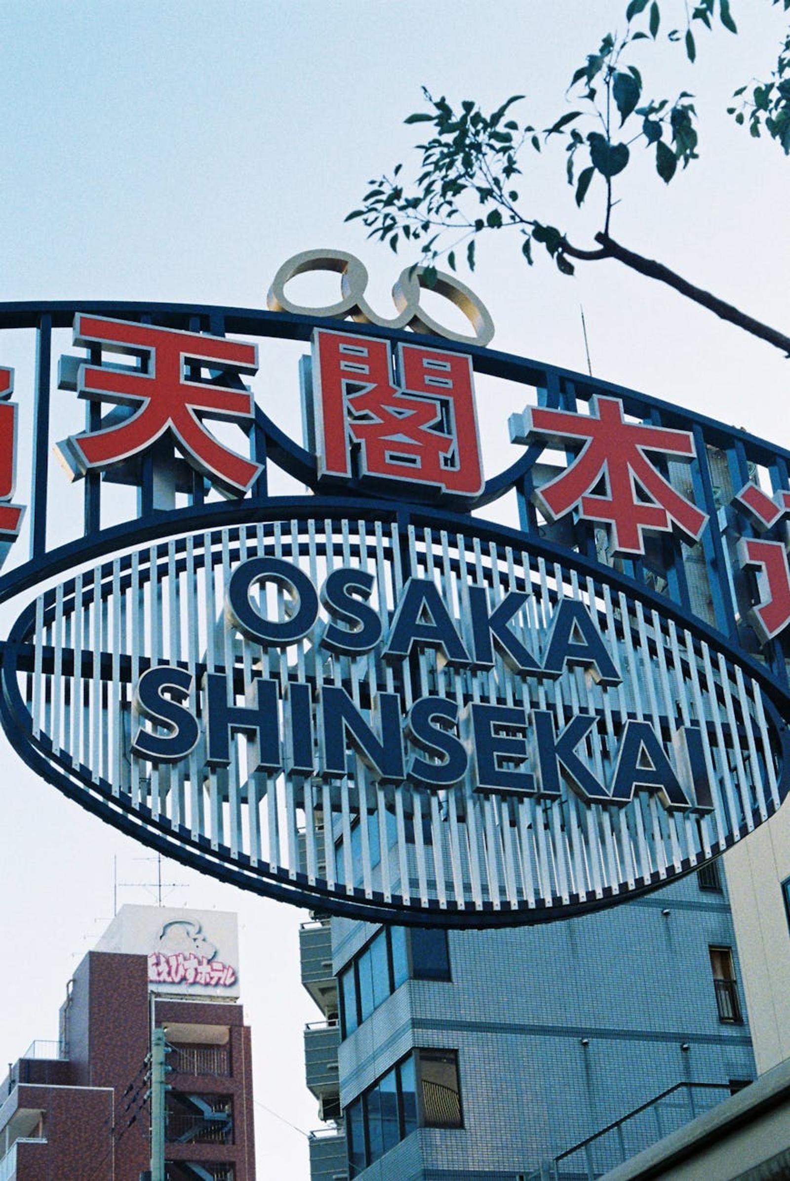 Large ring-shaped Osaka Shinsekai sign with Japanese lettering against the sky