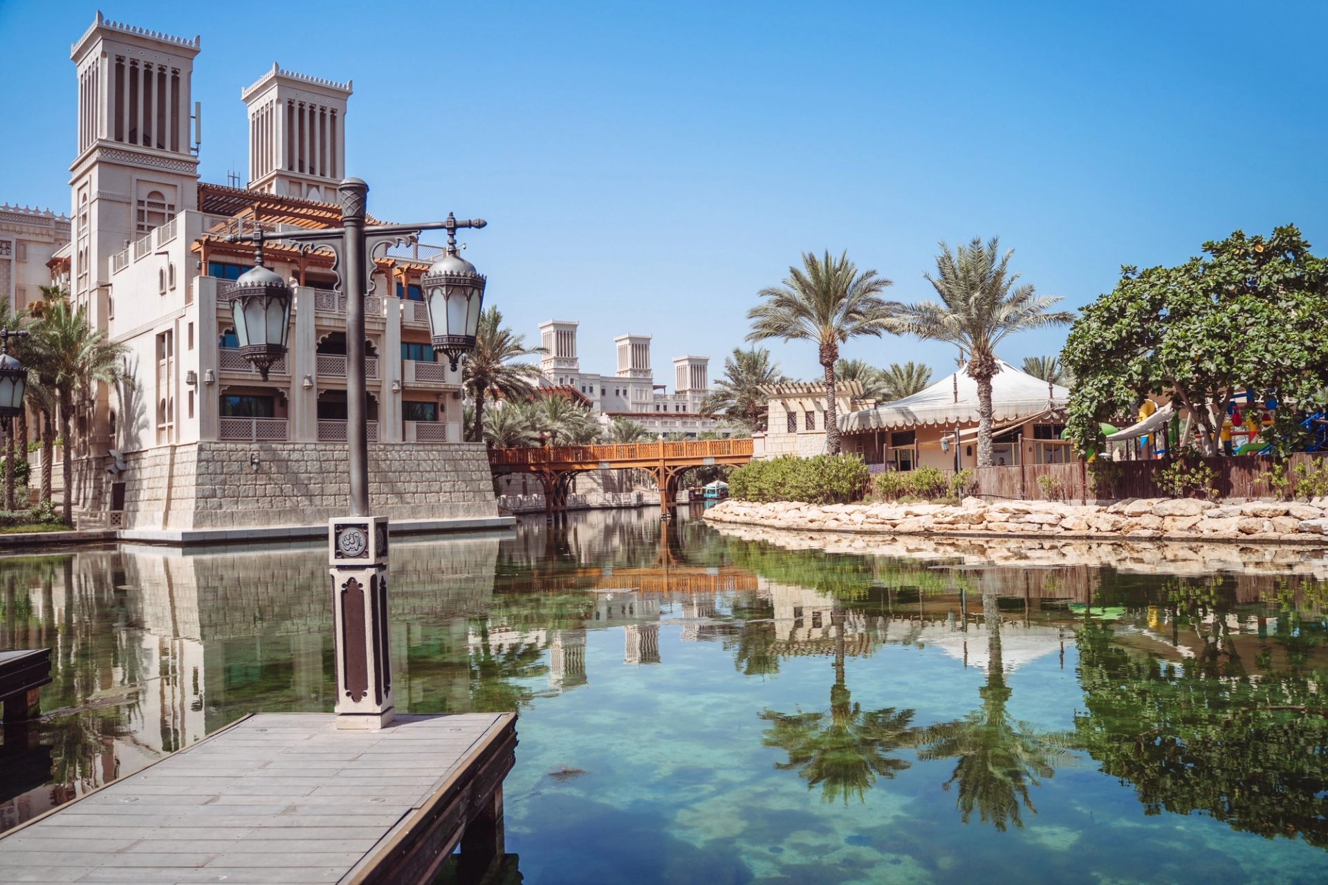 Explore the serene setting of Madinat Jumeirah Resort in Dubai, featuring traditional architecture and lush palm trees