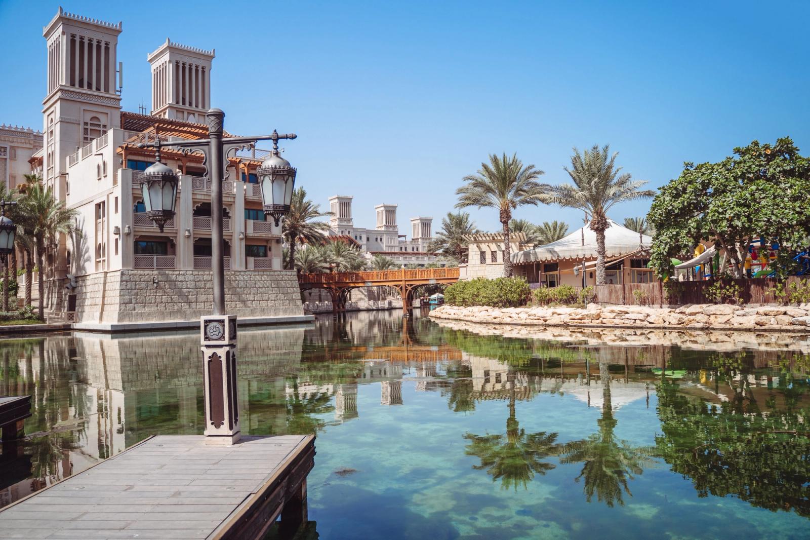 Explore the serene setting of Madinat Jumeirah Resort in Dubai, featuring traditional architecture and lush palm trees