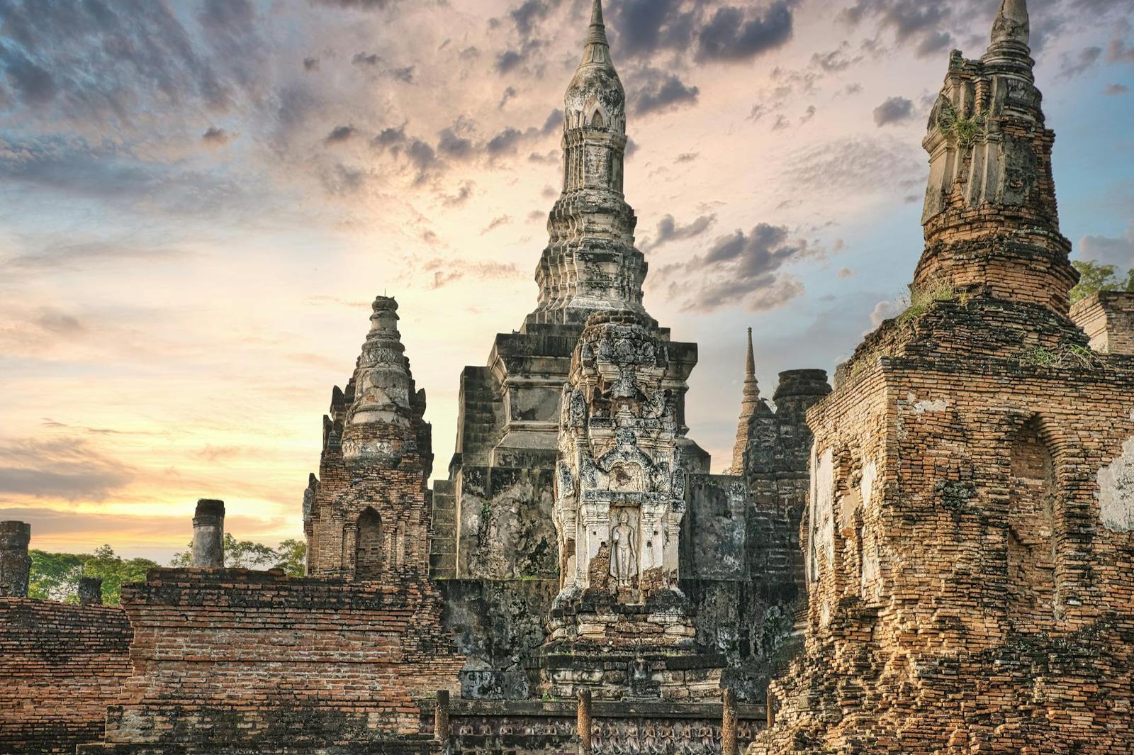 Ancient temple ruins of Wat Mahathat with a stunning sunset sky in Sukhothai, Thailand