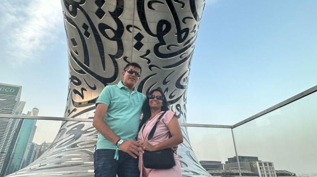 Couple posing in front of the Museum of the Future, Dubai.