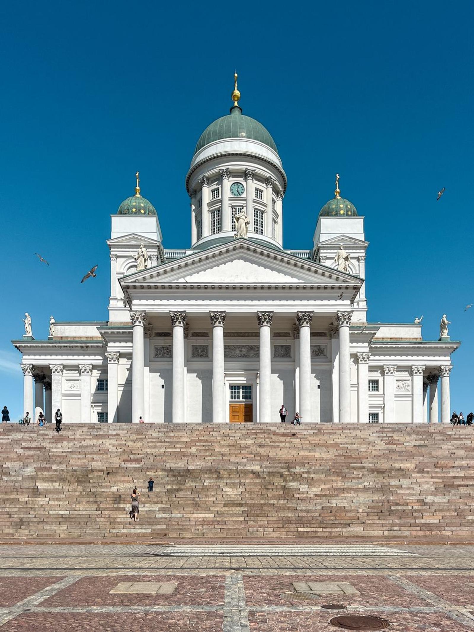 A sunlit view of the iconic Helsinki Cathedral with a clear blue sky in the background
