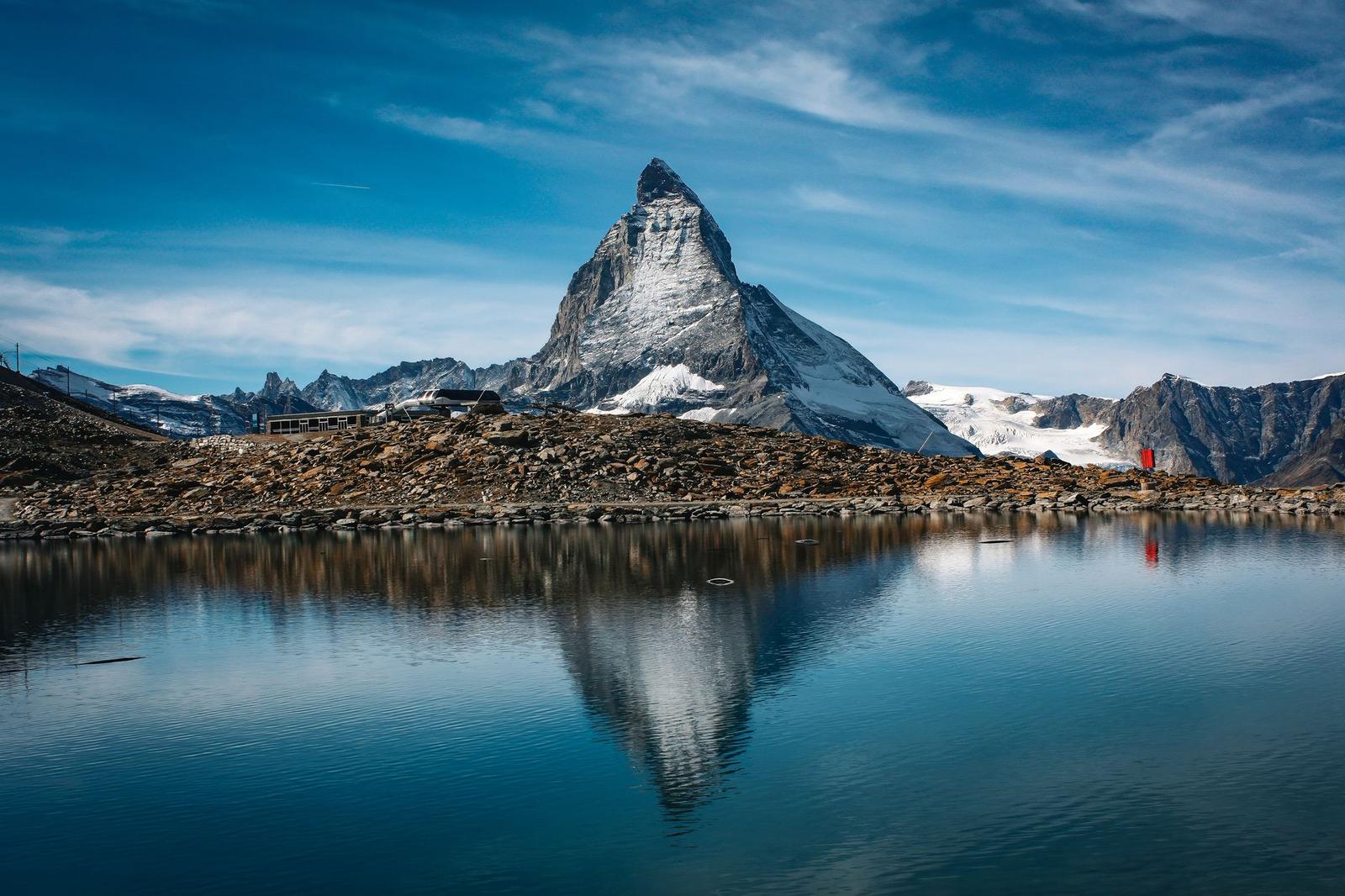 Stunning view of the iconic Matterhorn mountain reflecting in a calm lake under a clear blue sky
