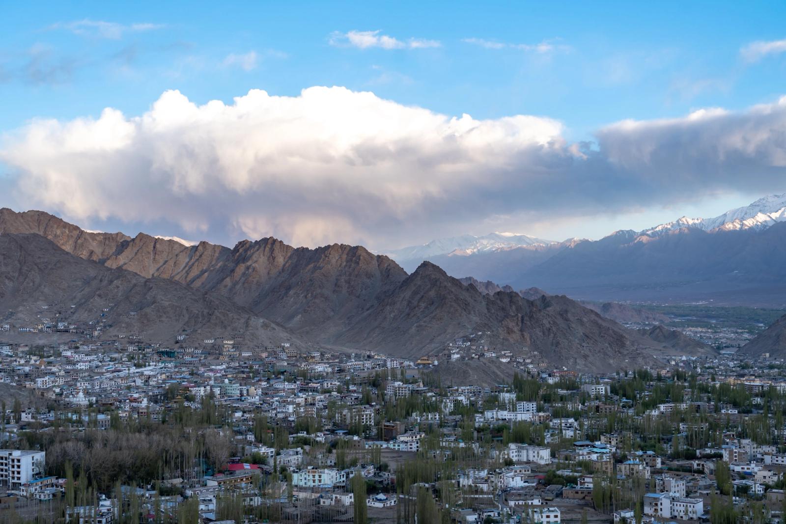 Breathtaking view of Leh town surrounded by towering mountains and clear blue skies