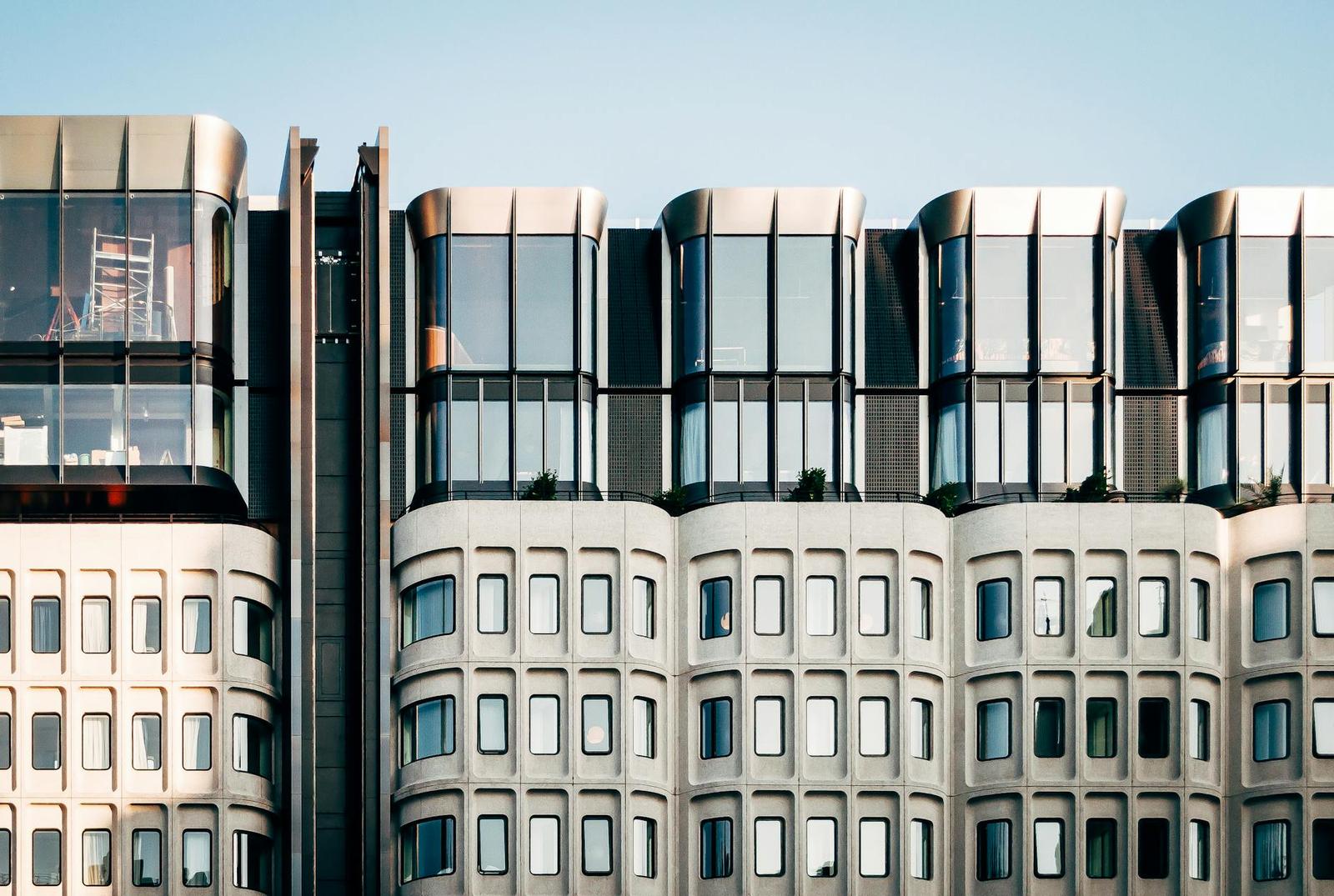 A modern glass and concrete building facade with rounded window bays