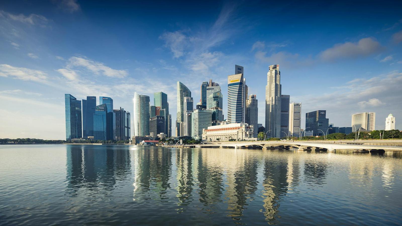 Capture of Singapore's modern skyline featuring reflective skyscrapers against a blue sky