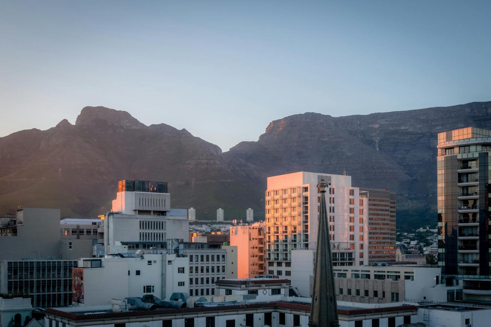 City skyline silhouetted against mountains bathed in dusk light