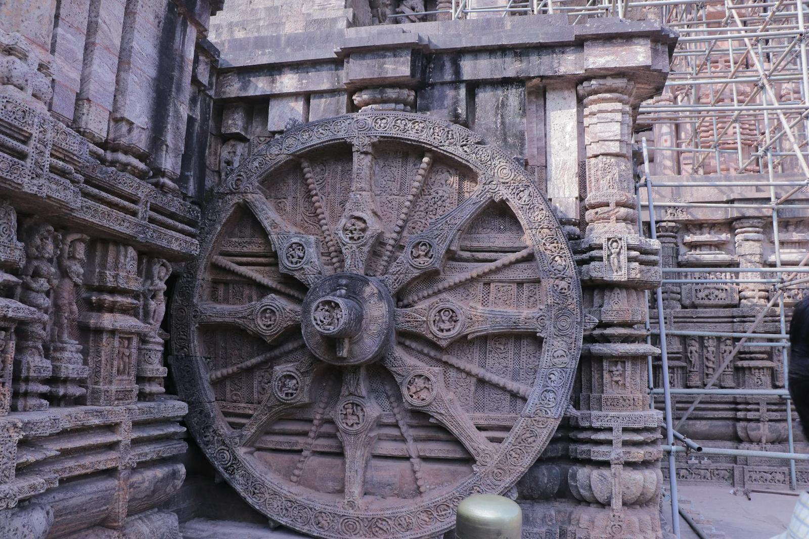 A massive carved stone wheel set into a temple's ornately sculpted wall