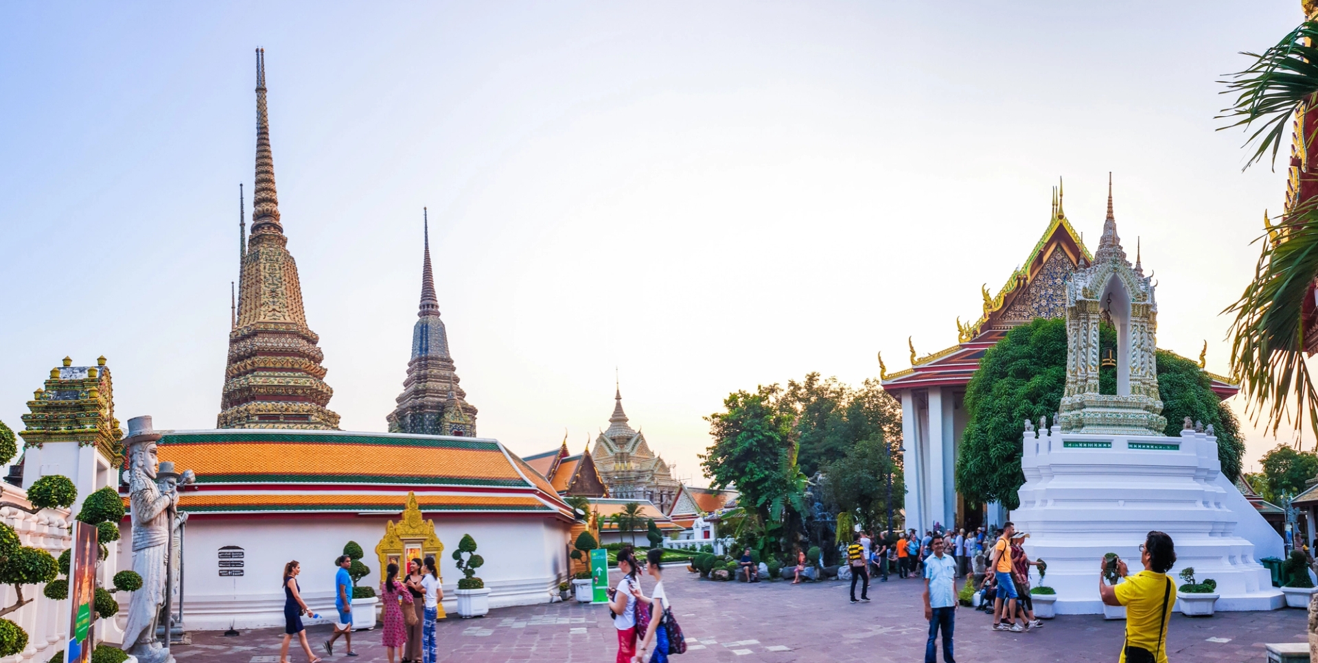 Vibrant view of tourists exploring Wat Phra Chetuphon, a majestic temple in Bangkok, Thailand