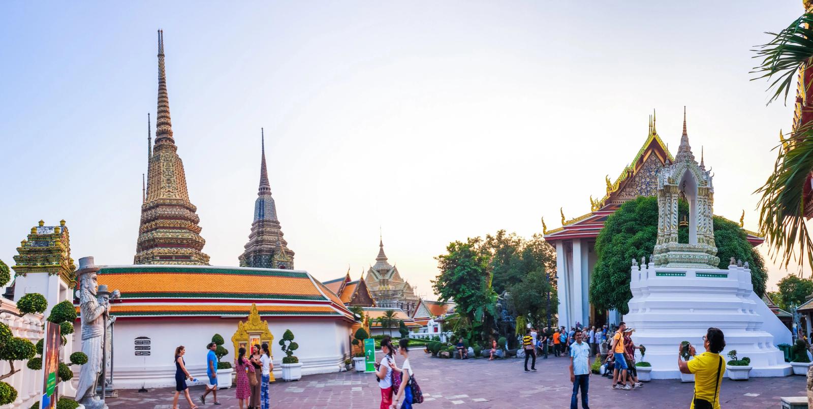 Vibrant view of tourists exploring Wat Phra Chetuphon, a majestic temple in Bangkok, Thailand
