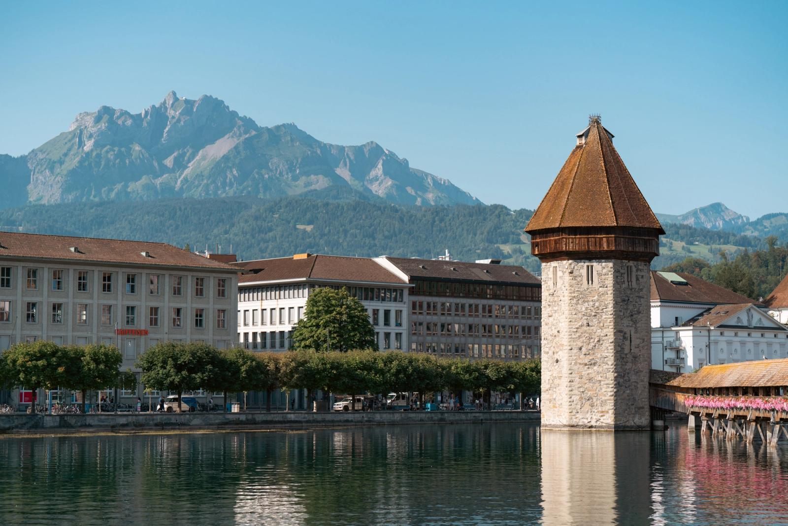 Scenic view of Chapel Bridge and Water Tower in Lucerne, Switzerland, with mountains in the background