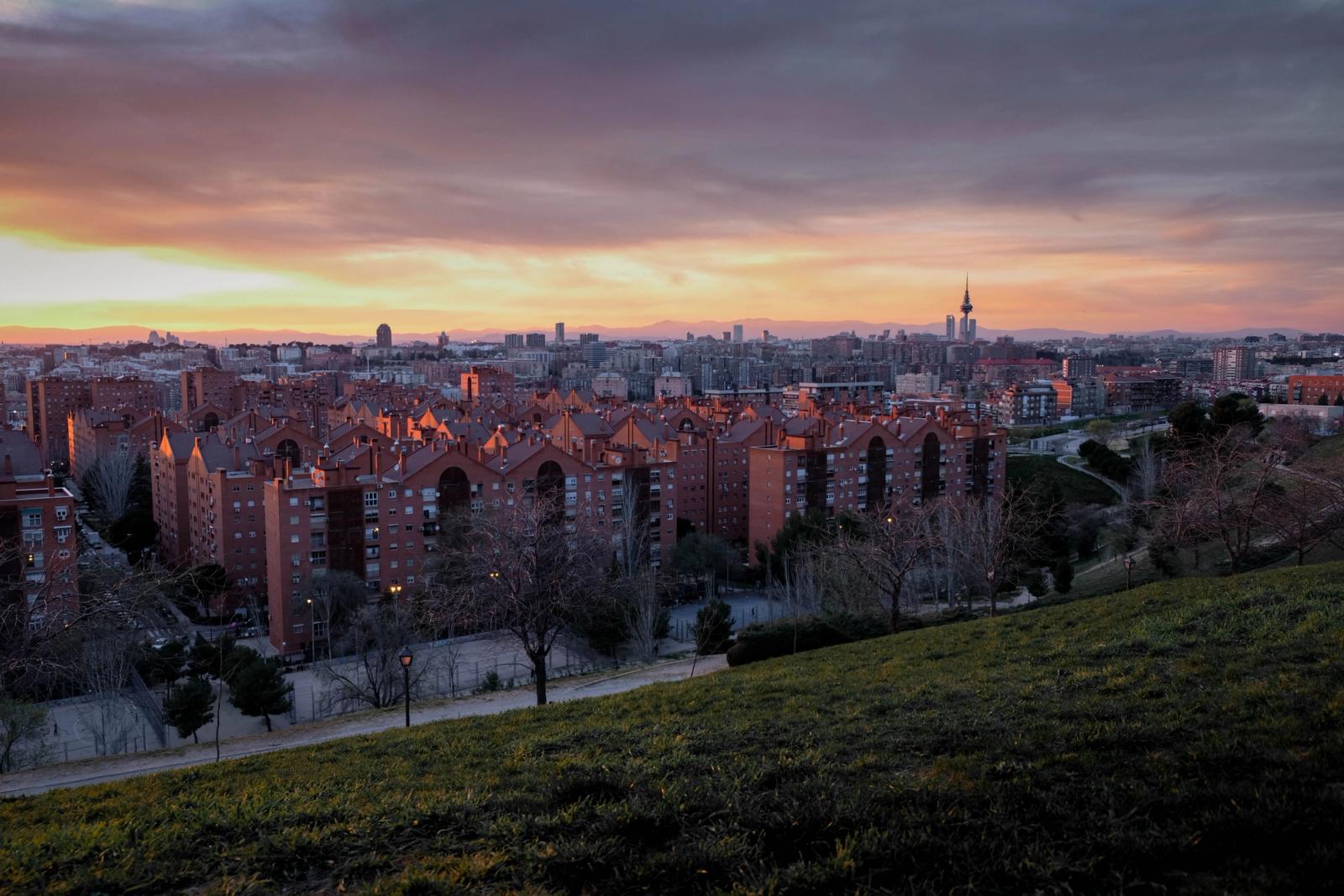Captivating view of Madrid's skyline at sunset from a park, showcasing urban architecture